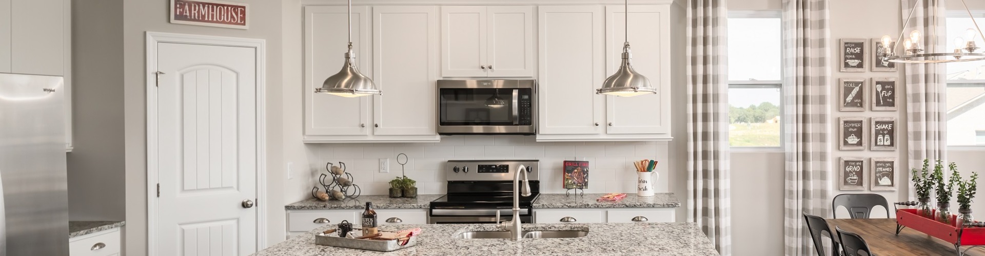 A kitchen with white cabinets.