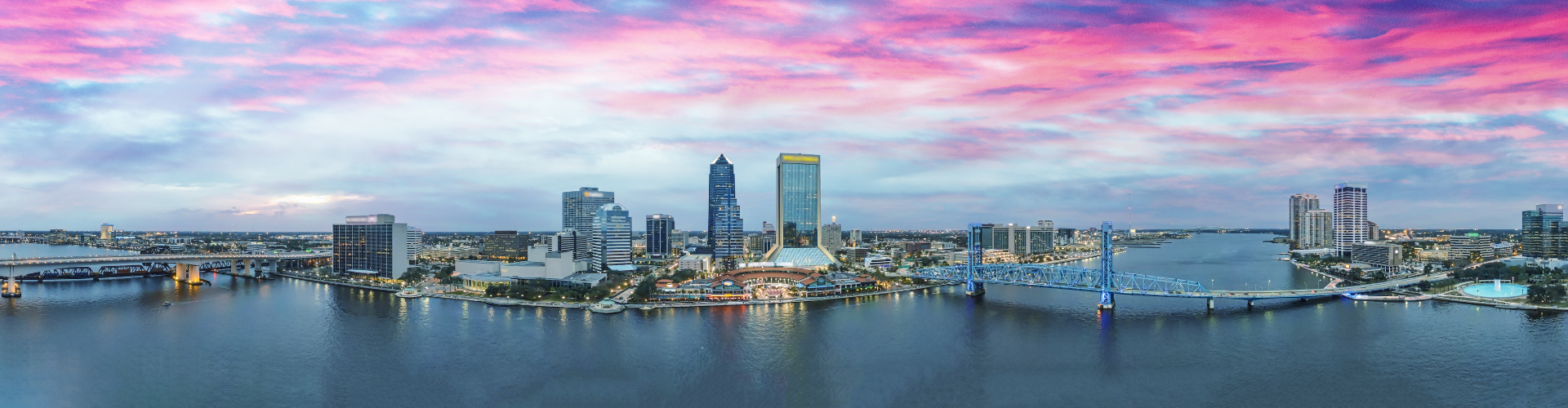 A city skyline with a bridge and a river.