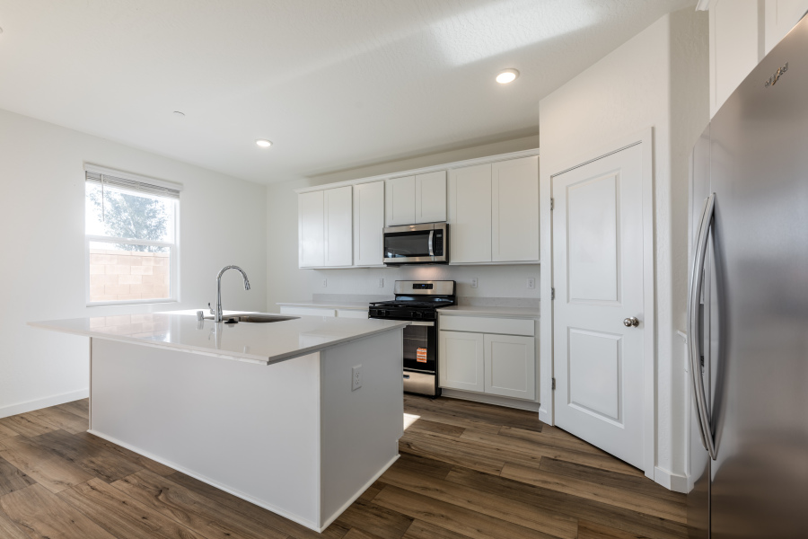 A kitchen with white cabinets.