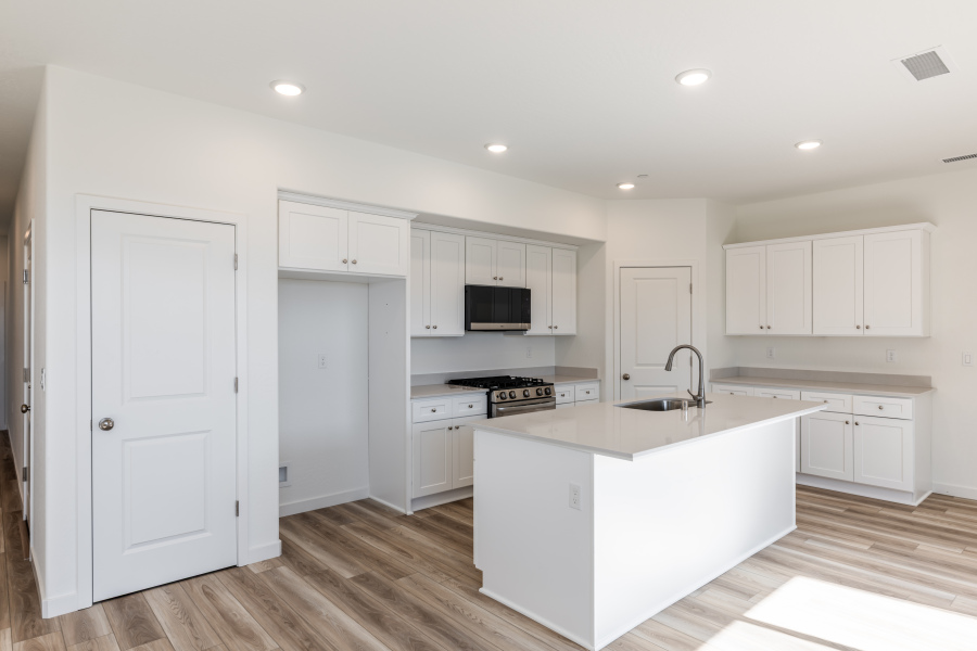 A kitchen with white cabinets.