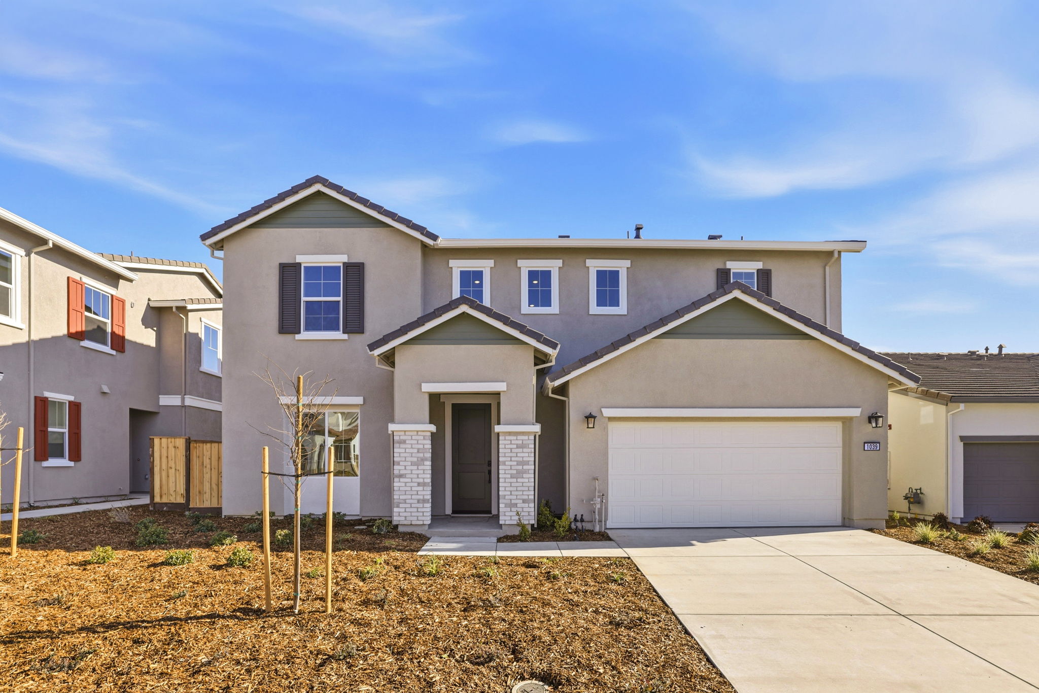 A house with garages and a sidewalk.