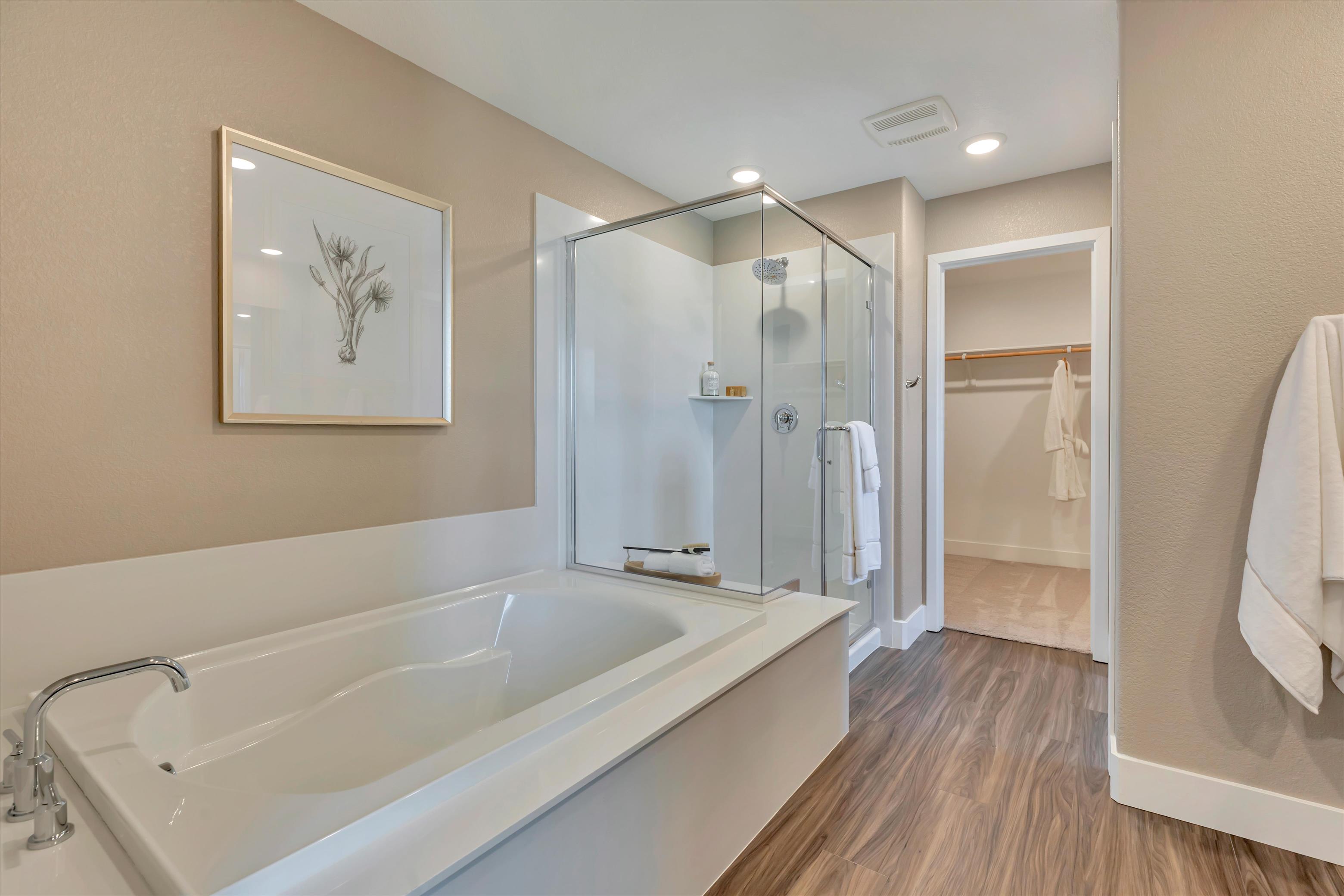 A bathroom with a tub and a mirror.