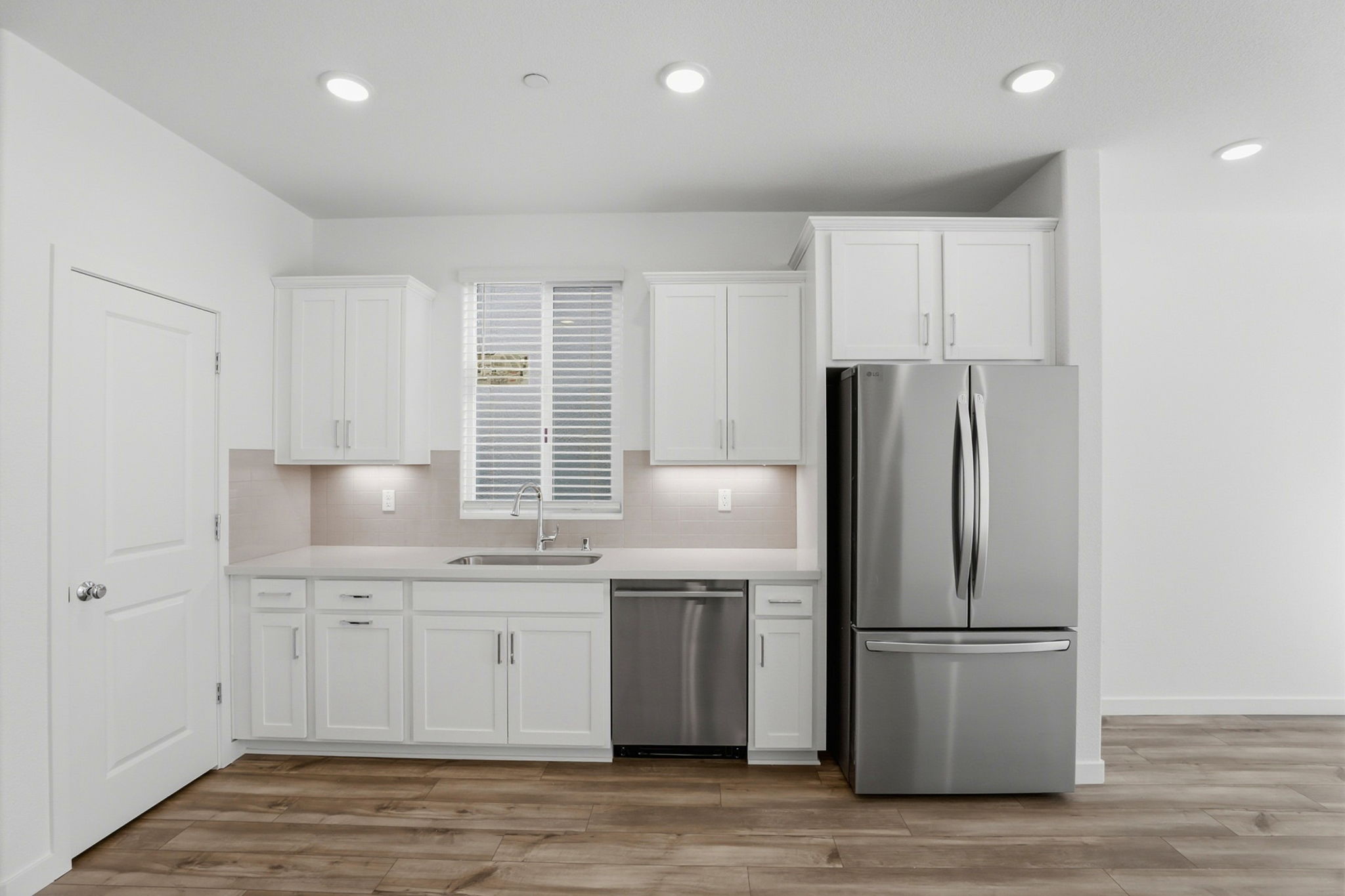 A kitchen with white cabinets.