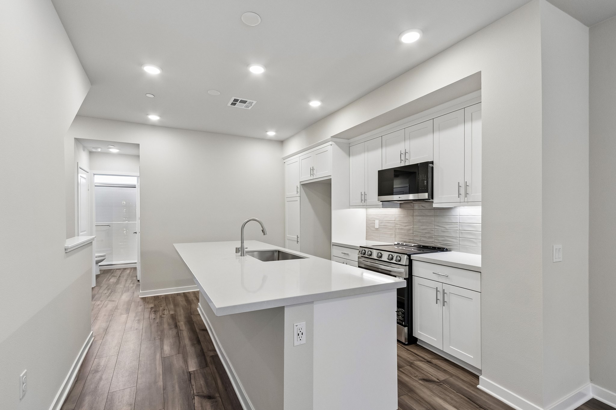 A kitchen with white cabinets.