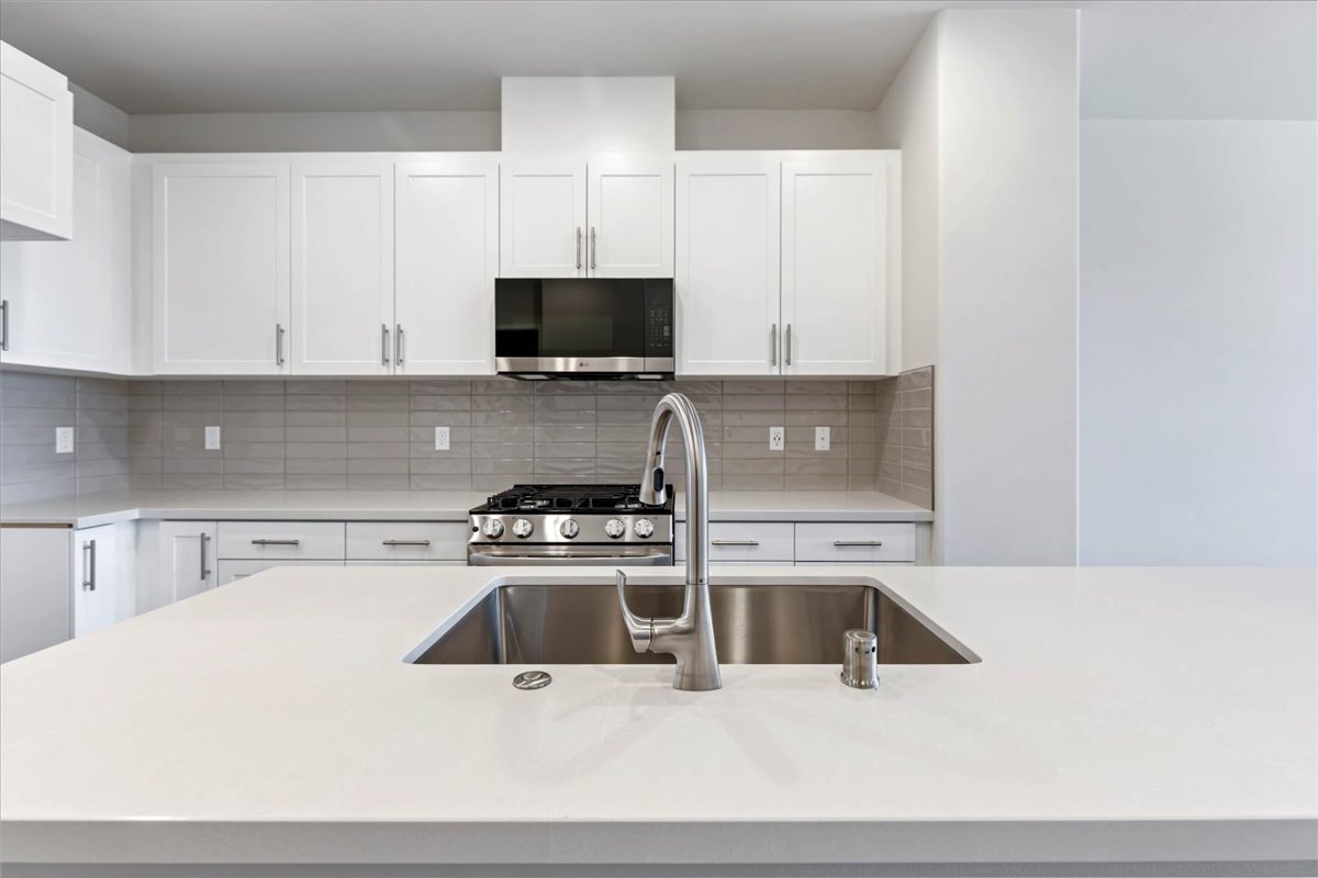 A kitchen with white cabinets.