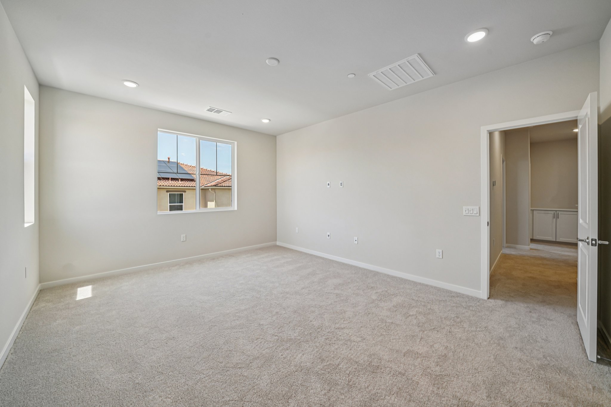 A room with a carpet and a window.