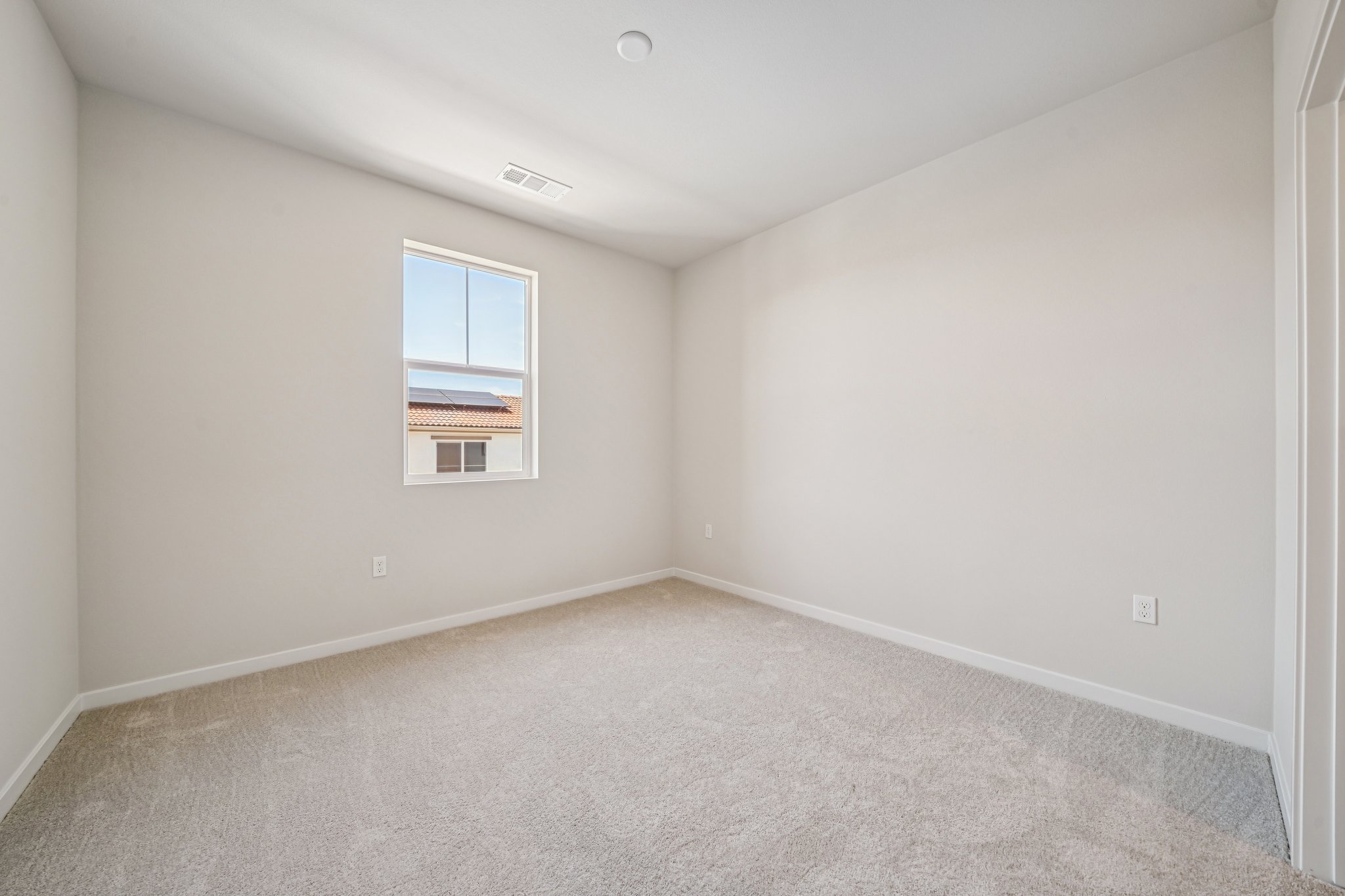 A room with a window and carpet.