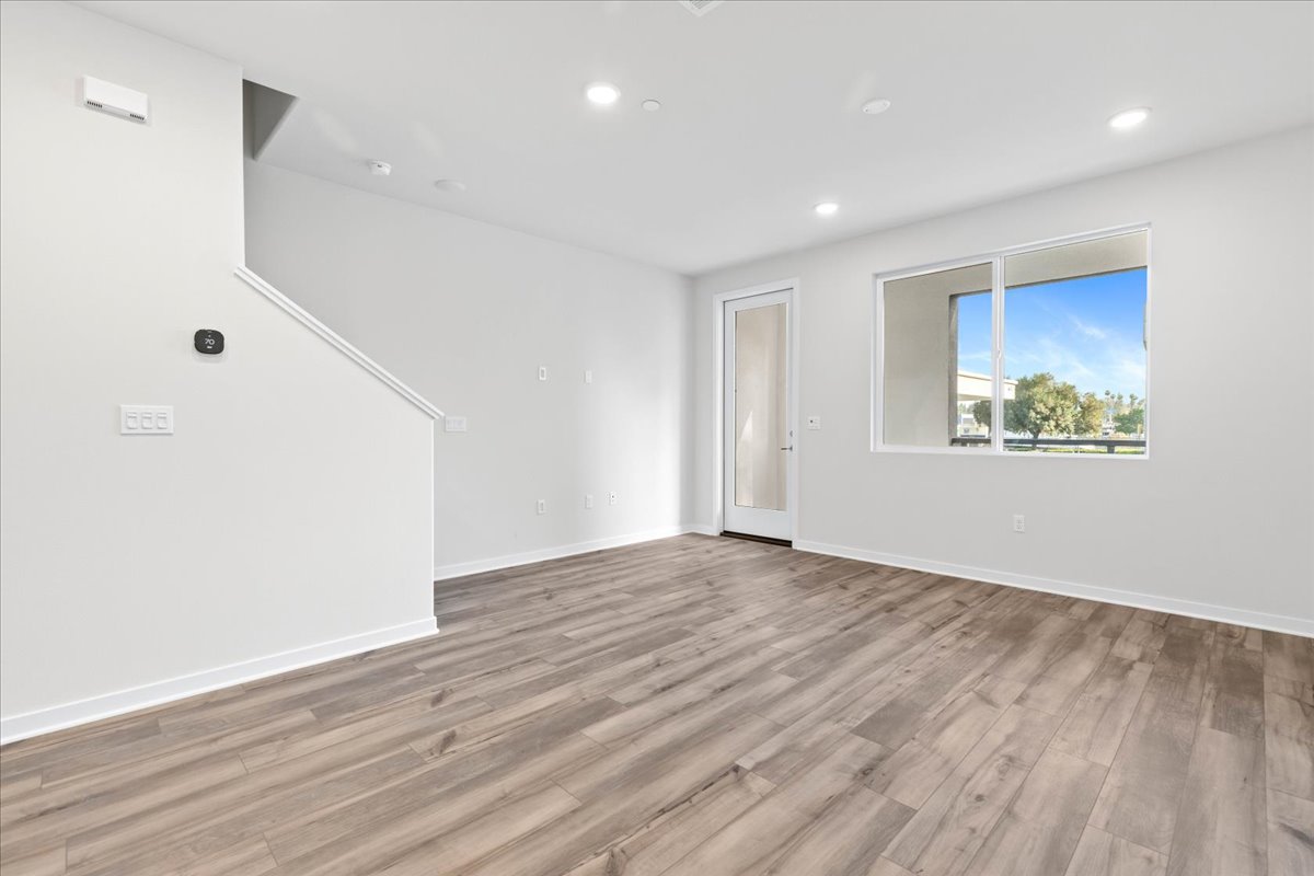 A room with a wood floor and a window.