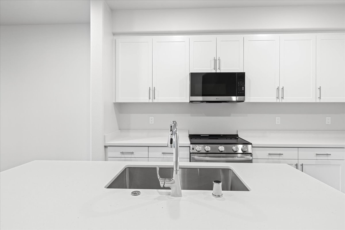 A kitchen with white cabinets.