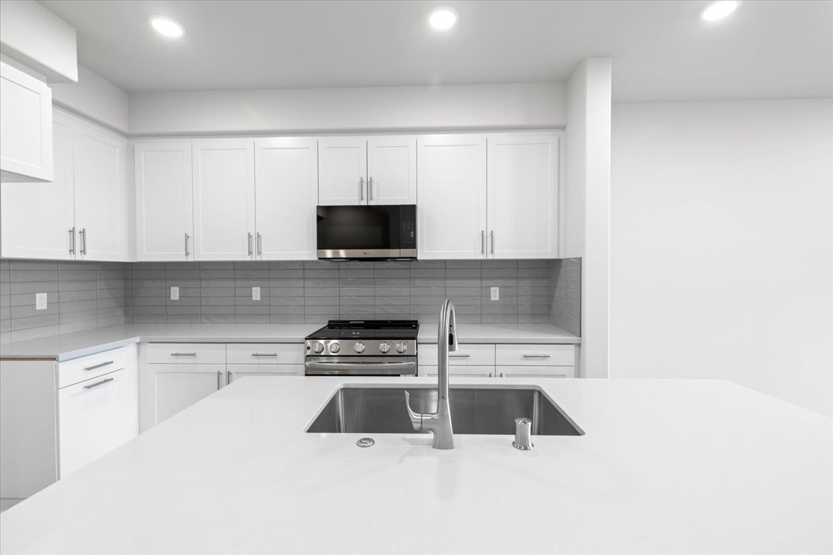 A kitchen with white cabinets.
