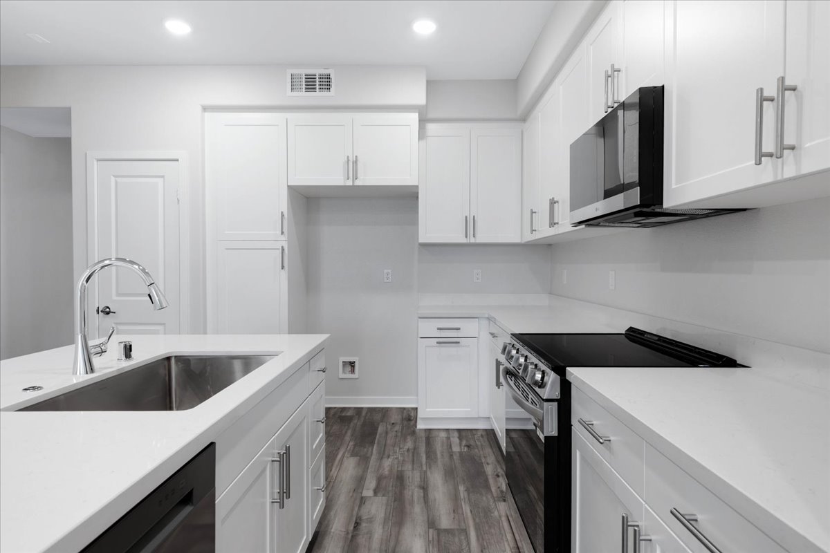 A kitchen with white cabinets.