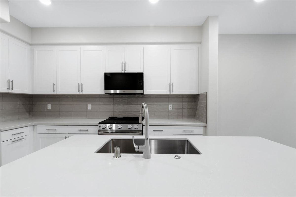 A kitchen with white cabinets.