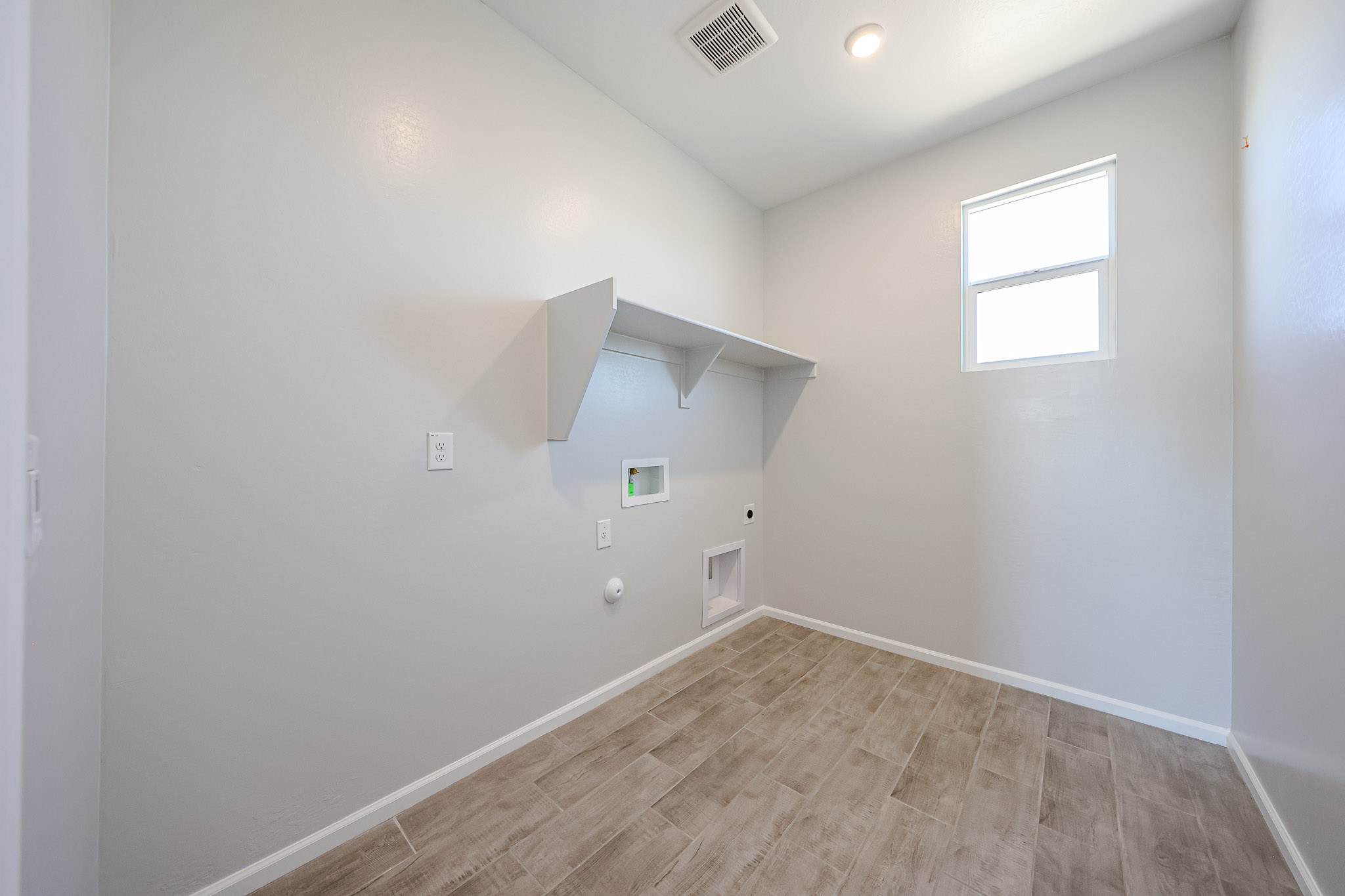 A room with a wood floor and white walls.