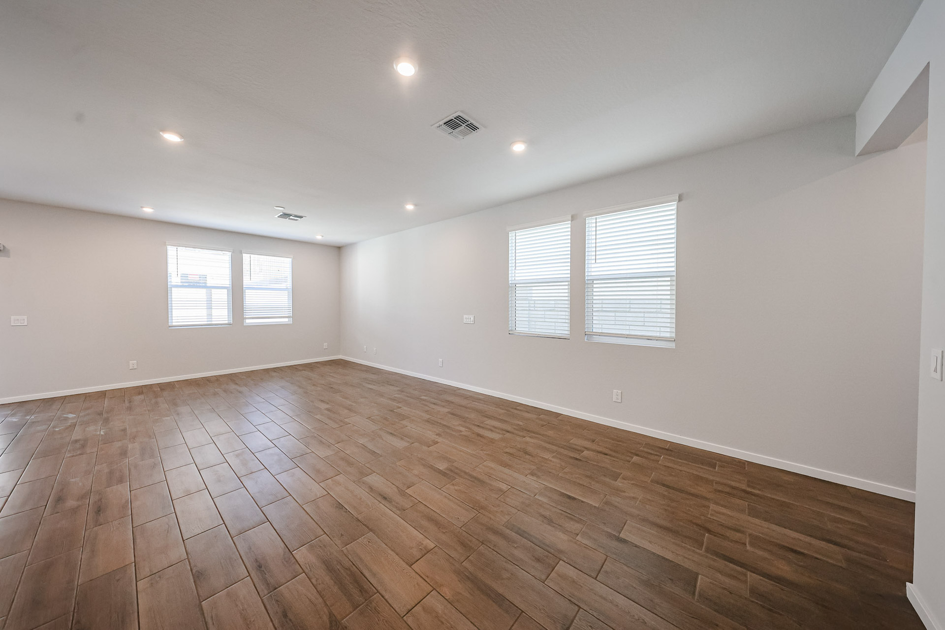 A room with a wood floor and windows.