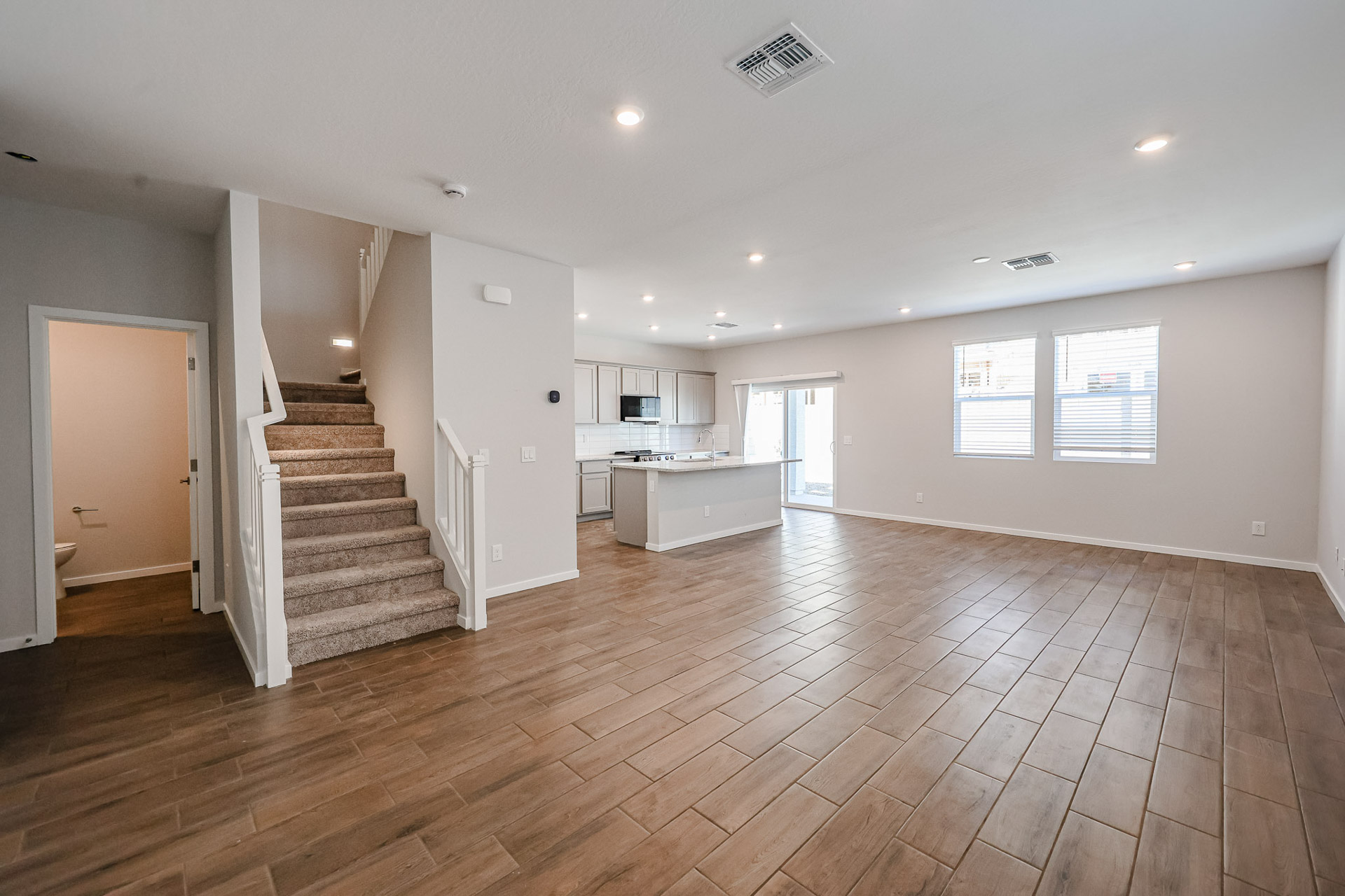 A large empty room with a wood floor and white walls.