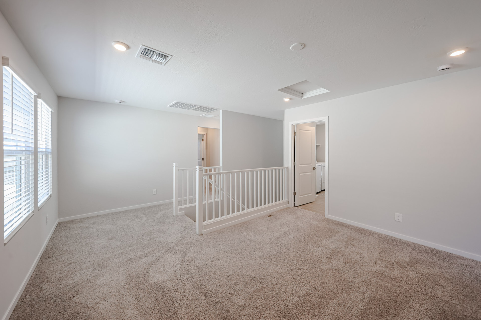 A room with a white railing and a white door.