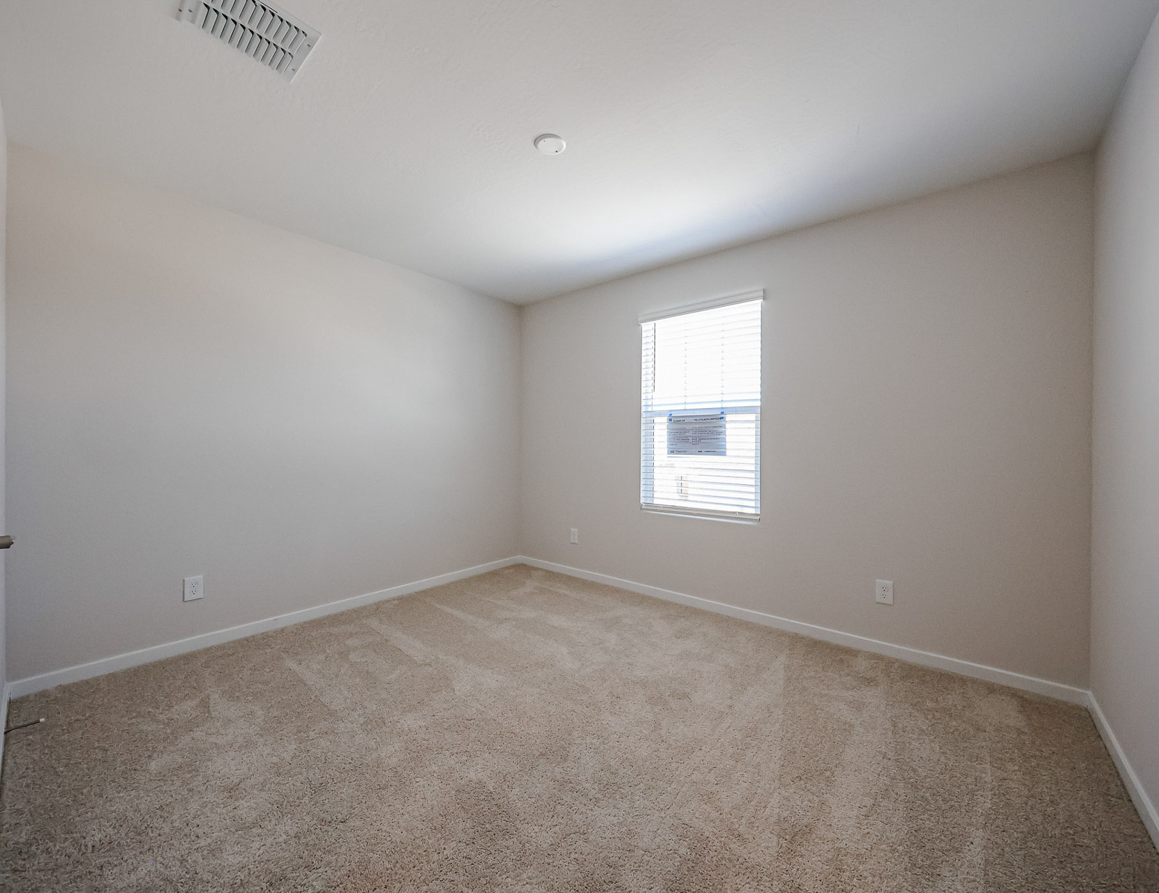 A room with a carpet and a window.