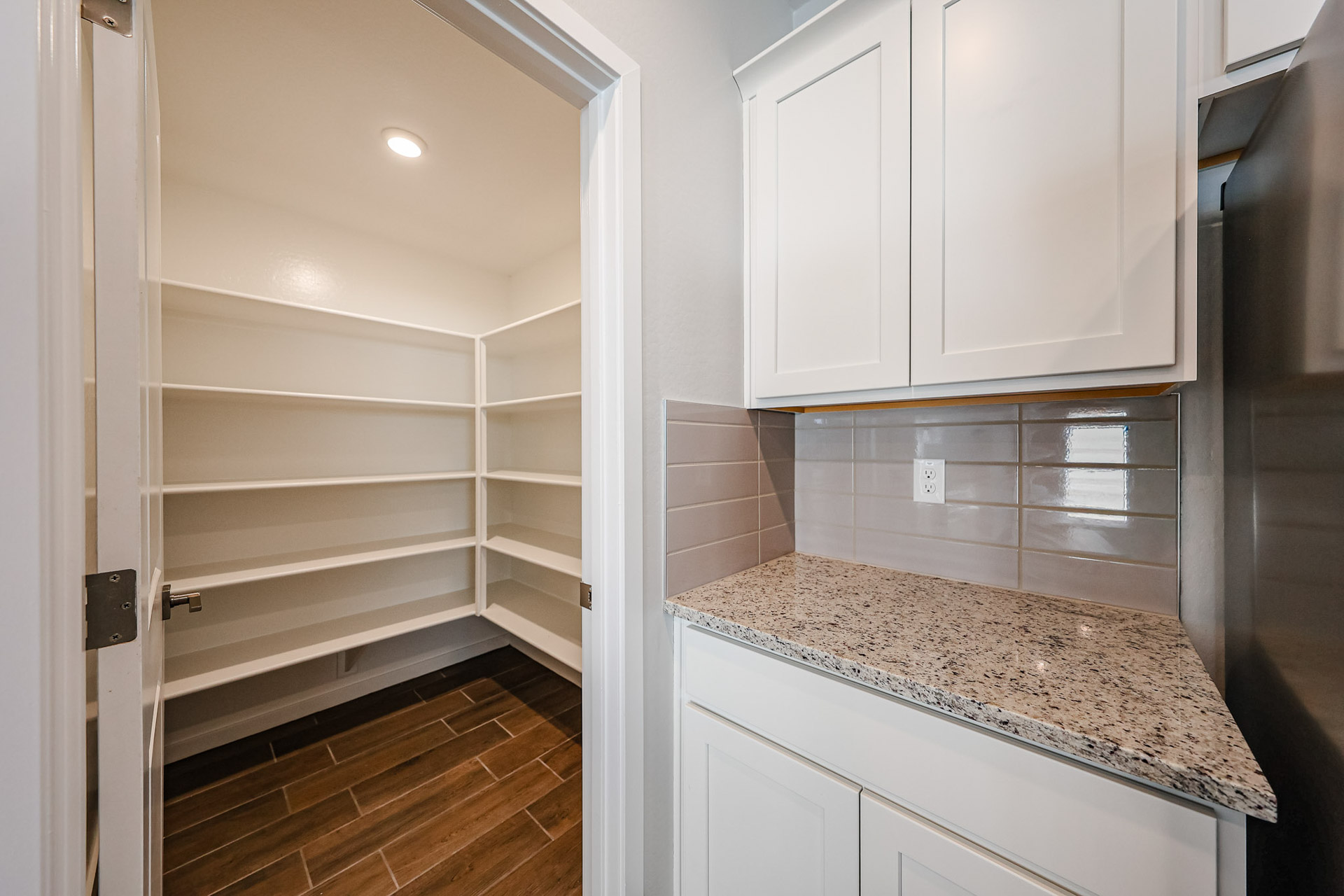 A kitchen with white cabinets.
