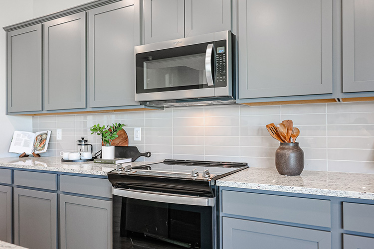 A kitchen with white cabinets.
