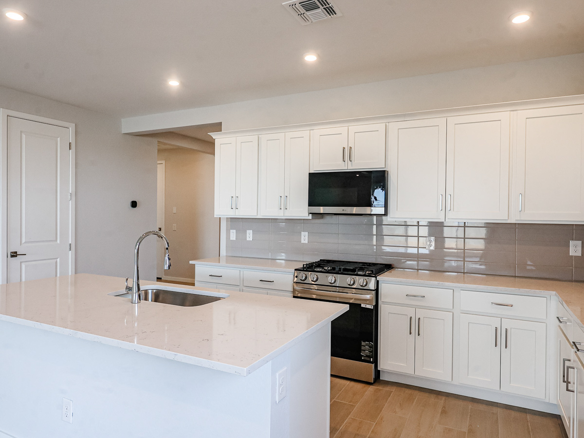 A kitchen with white cabinets.
