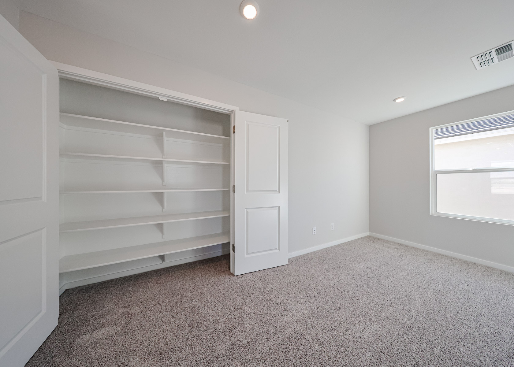A room with a white door and a white wall.