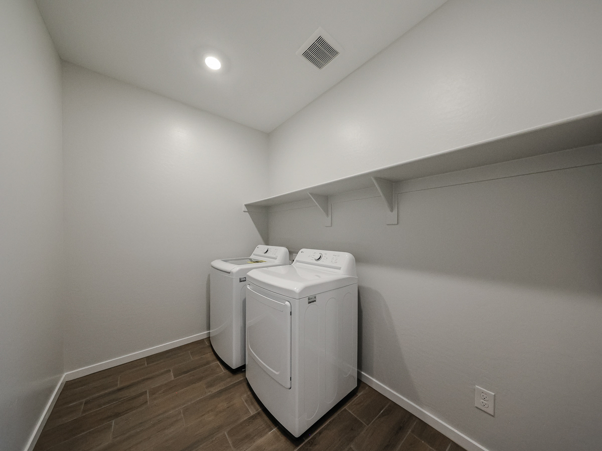 A room with a washing machine and a dryer.