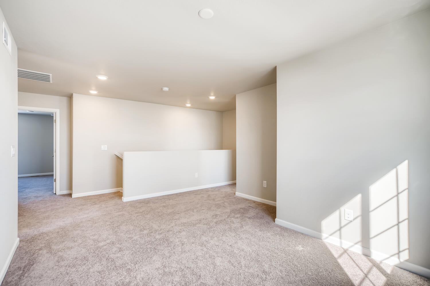 A room with a carpet and a staircase.