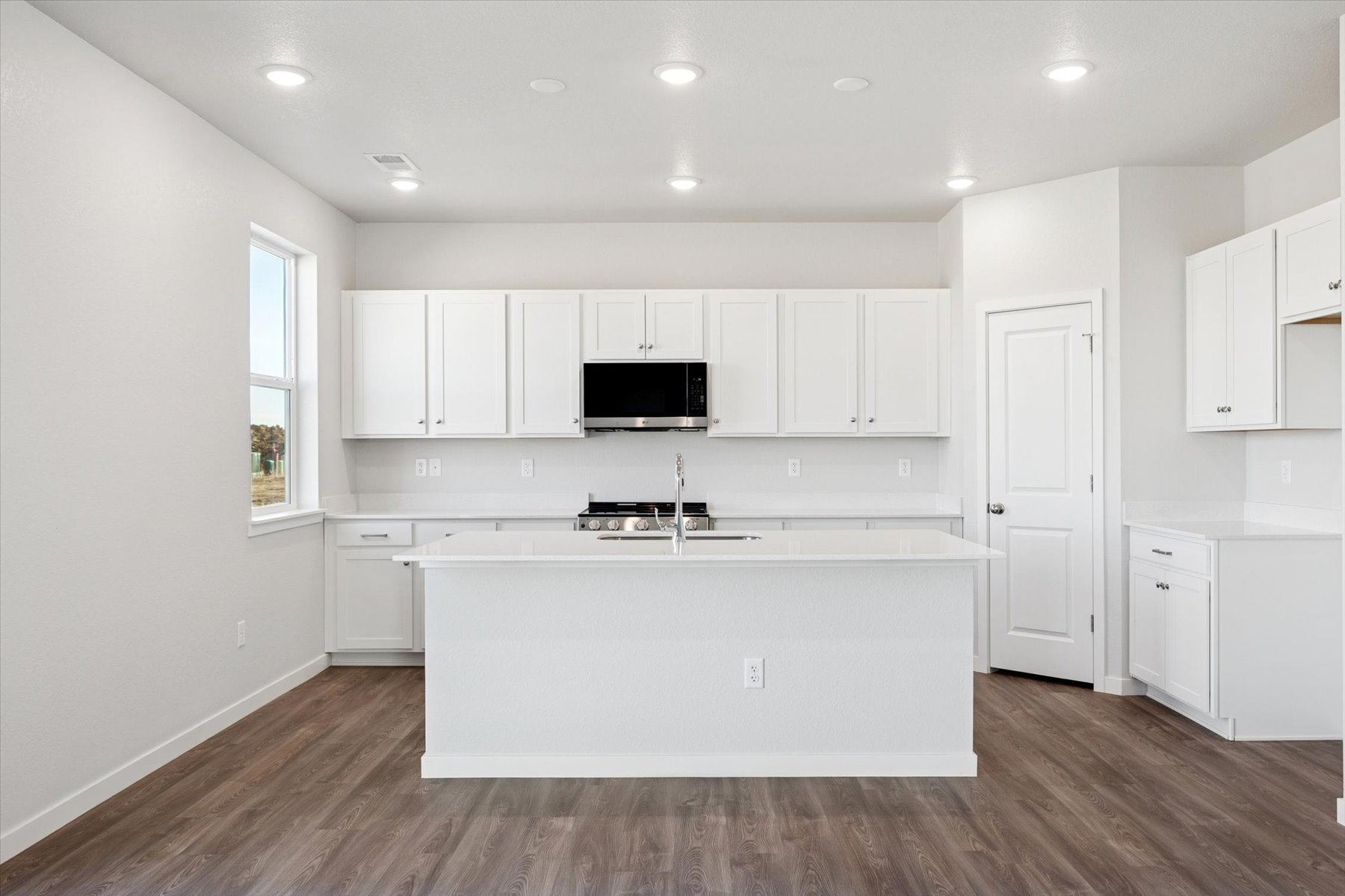 A kitchen with white cabinets.