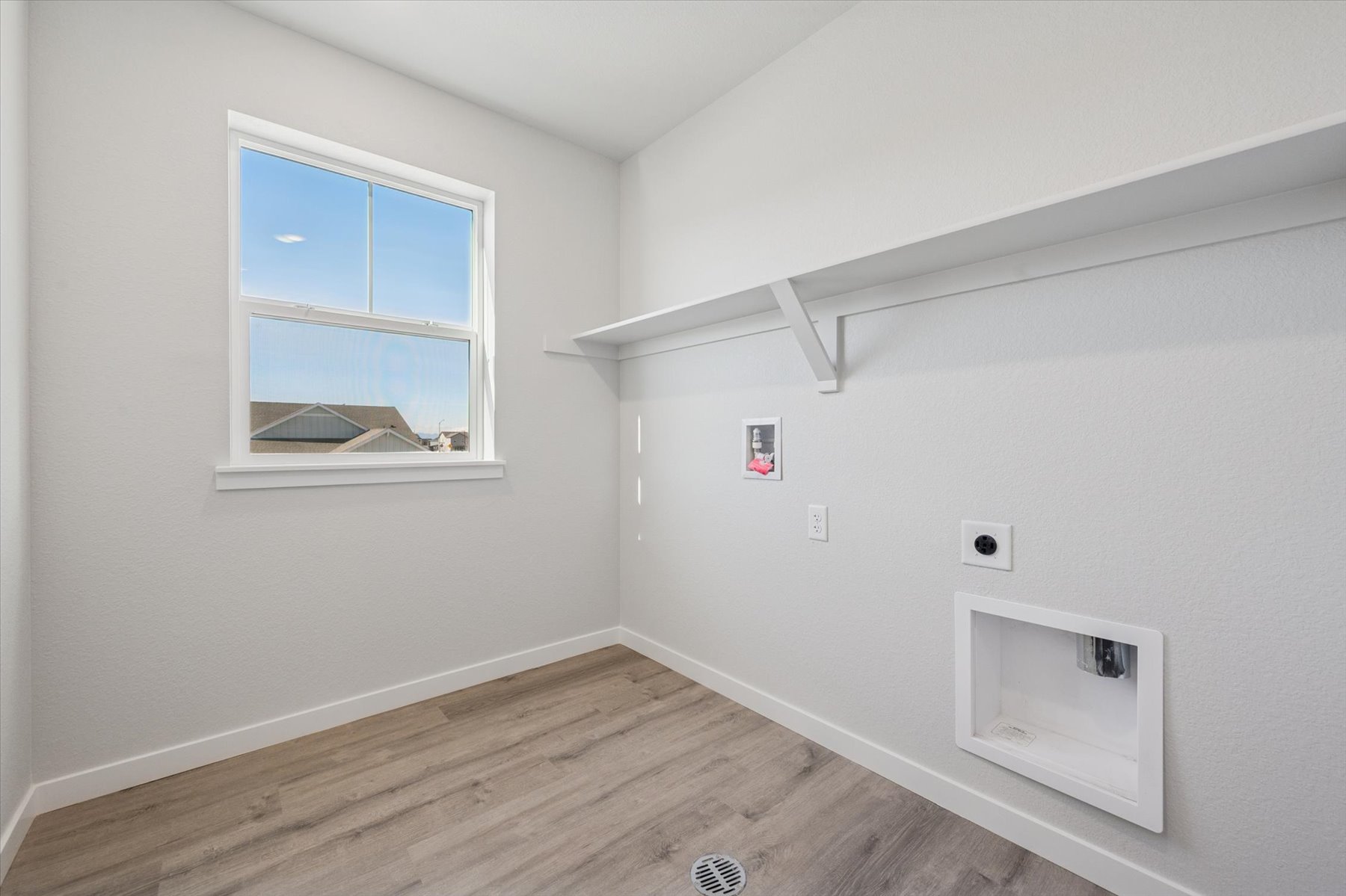 A room with a window and a wood floor.