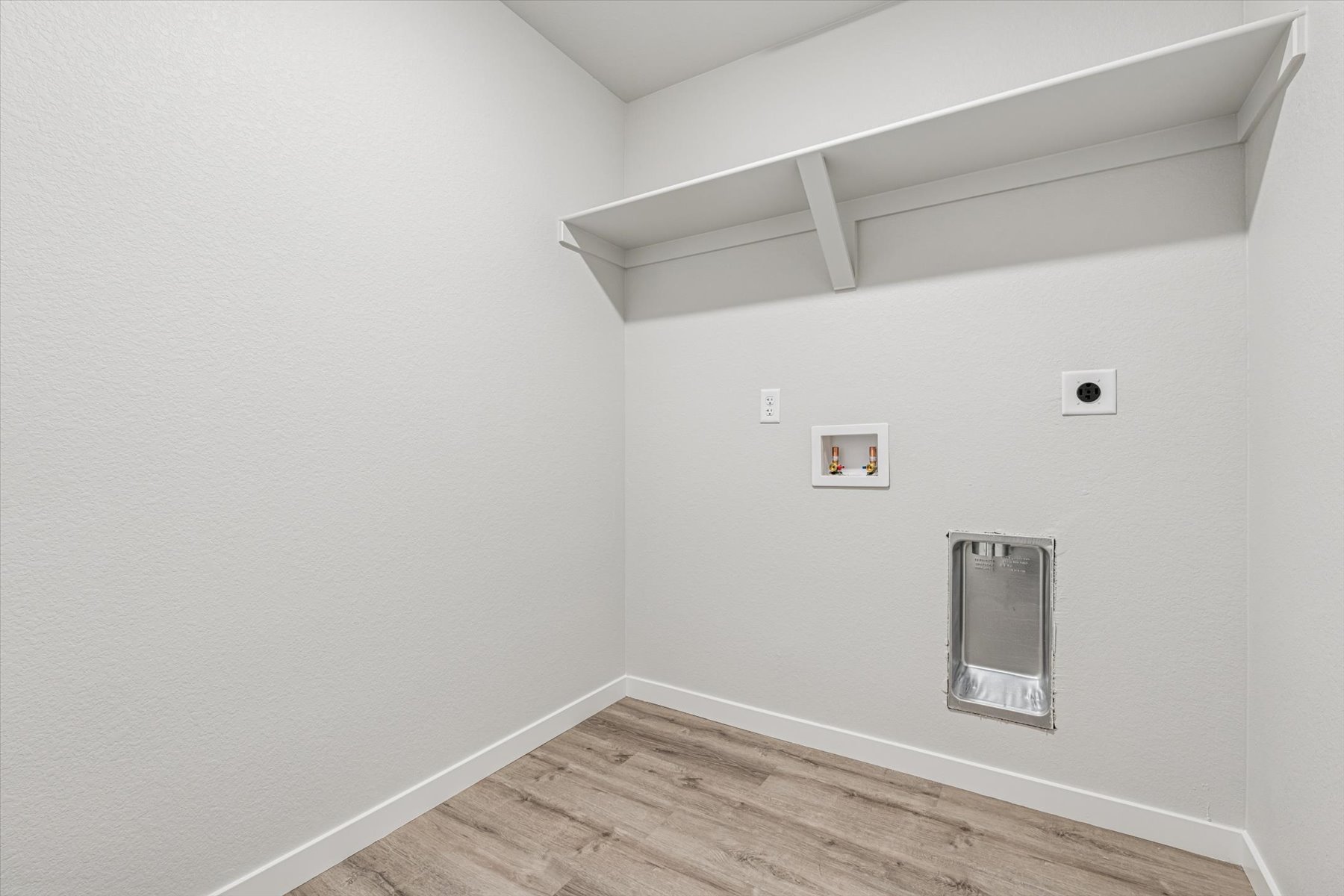 A white room with a wood floor and a wood floor.