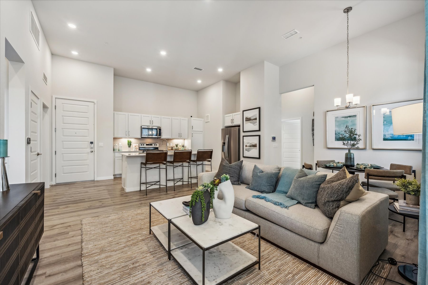 A living room with a large dining room and a large white wall.