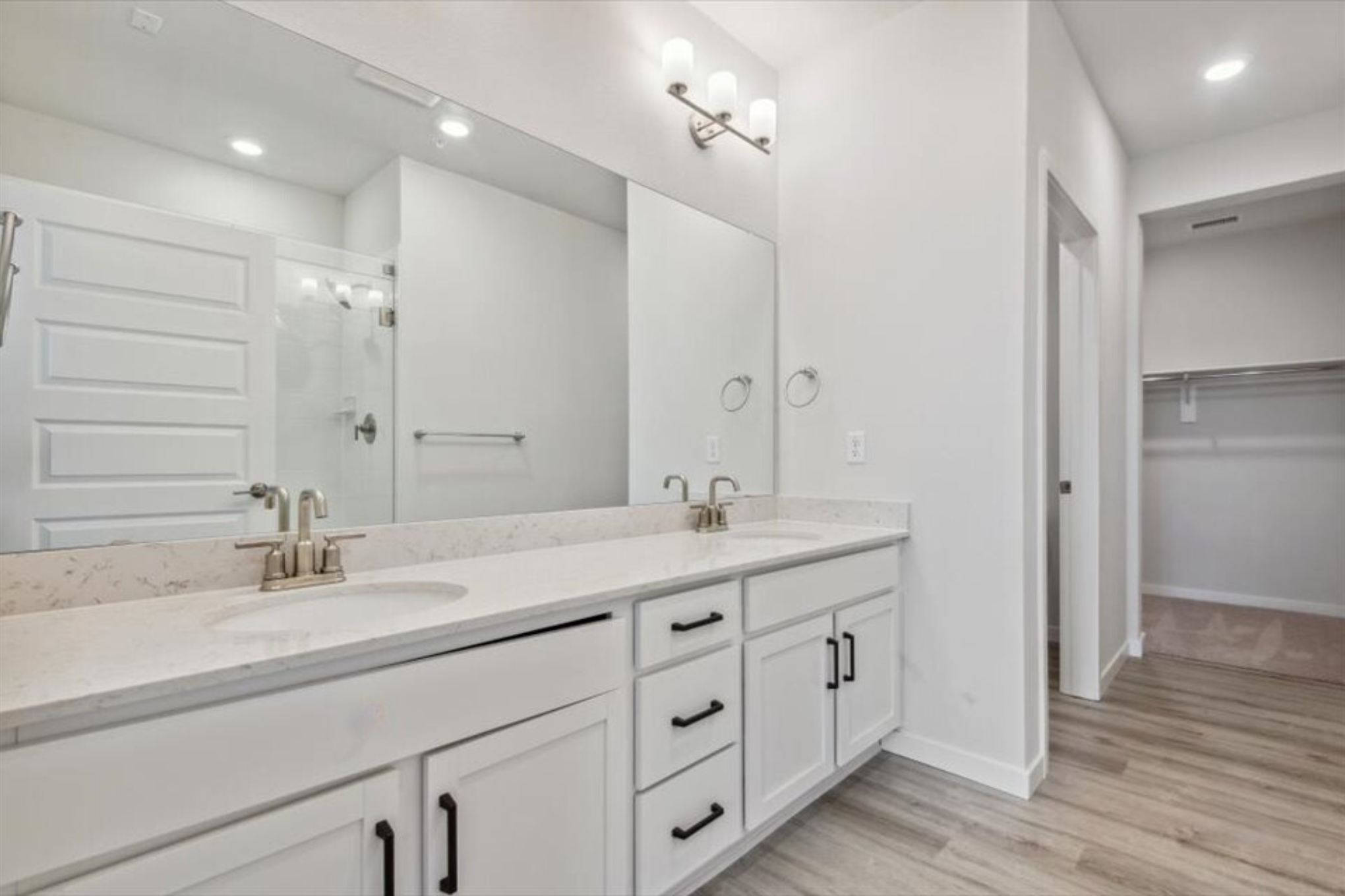 A bathroom with white cabinets.