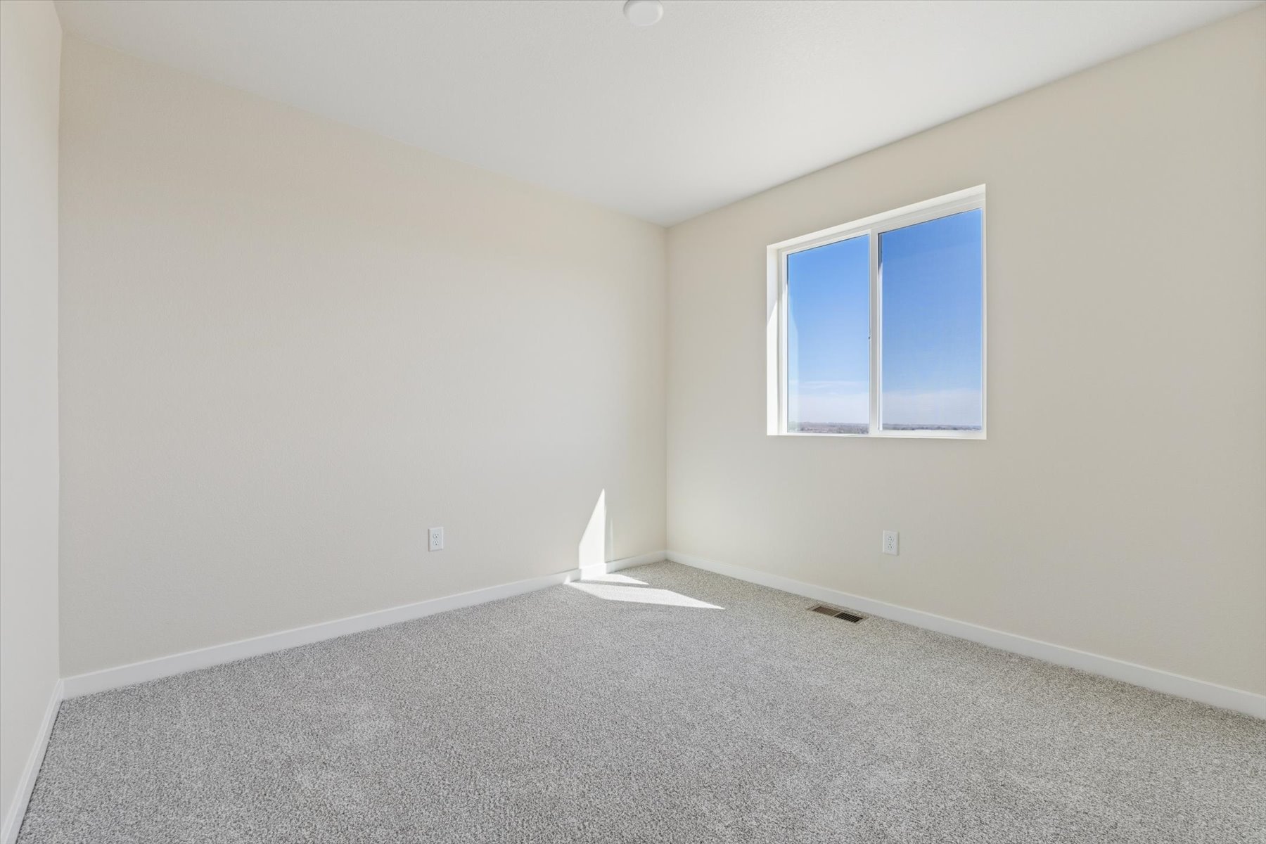 A room with a window and a carpet.