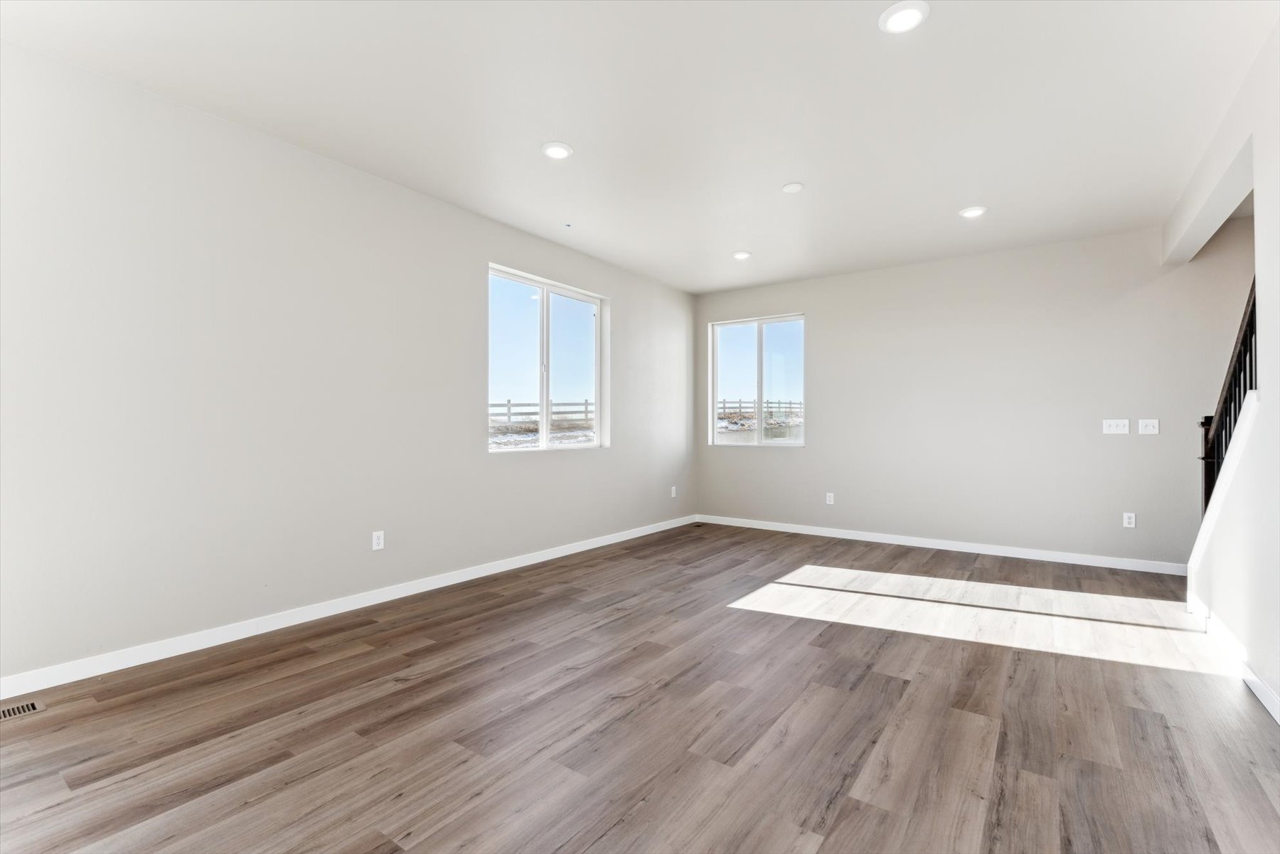 A room with a wood floor and windows.