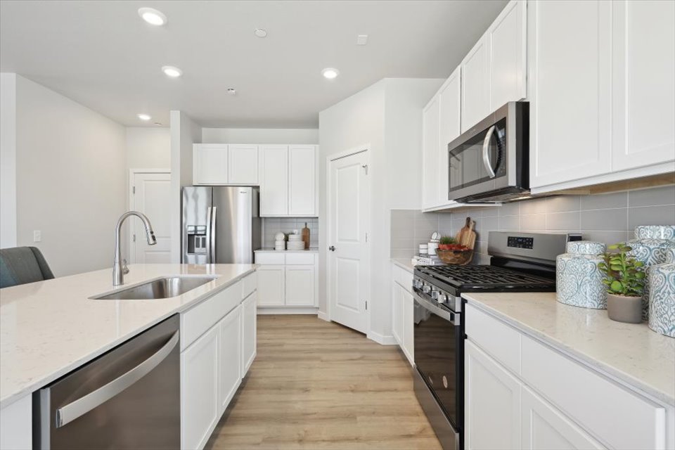 A kitchen with white cabinets.