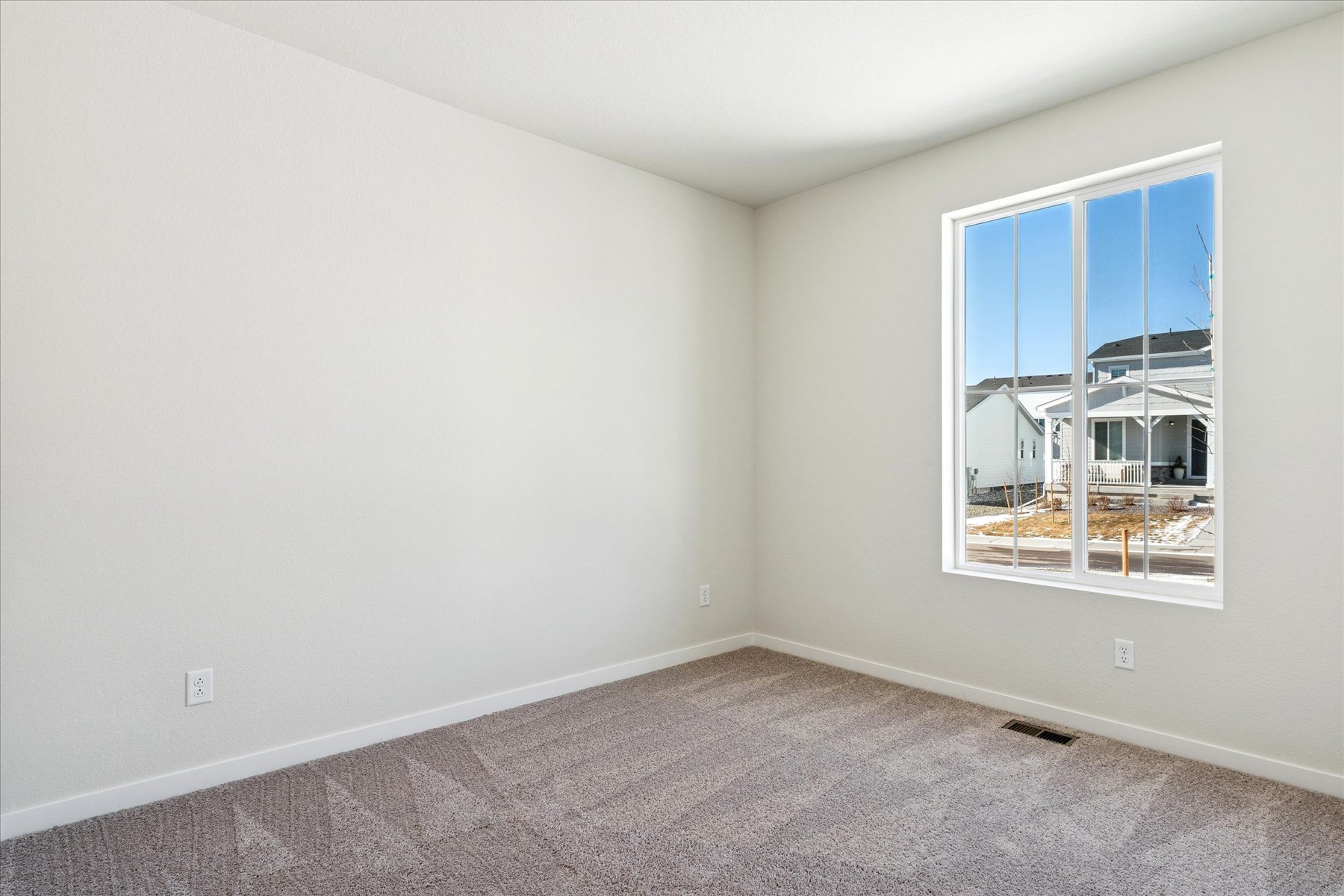 A room with a window and a carpet.