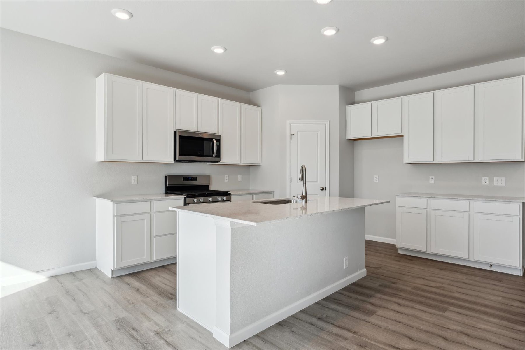 A kitchen with white cabinets.