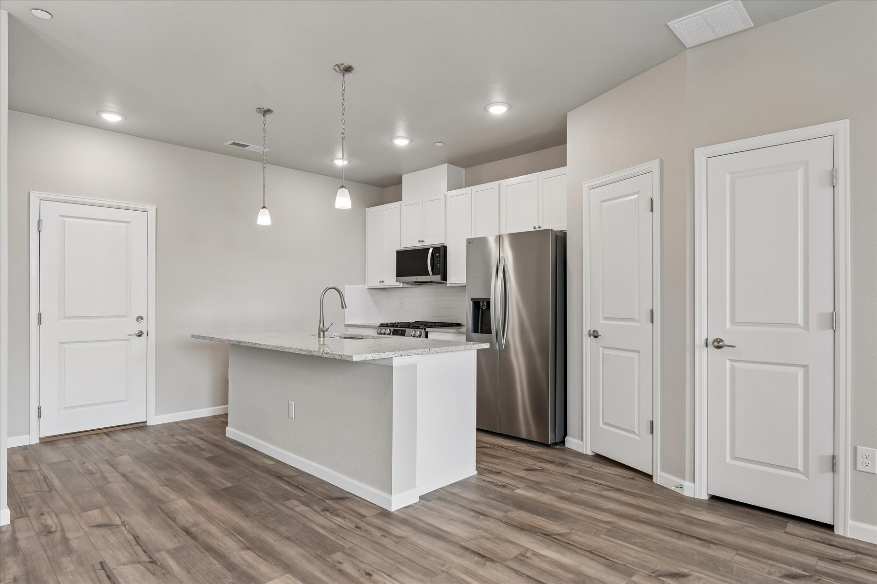A kitchen with white cabinets.
