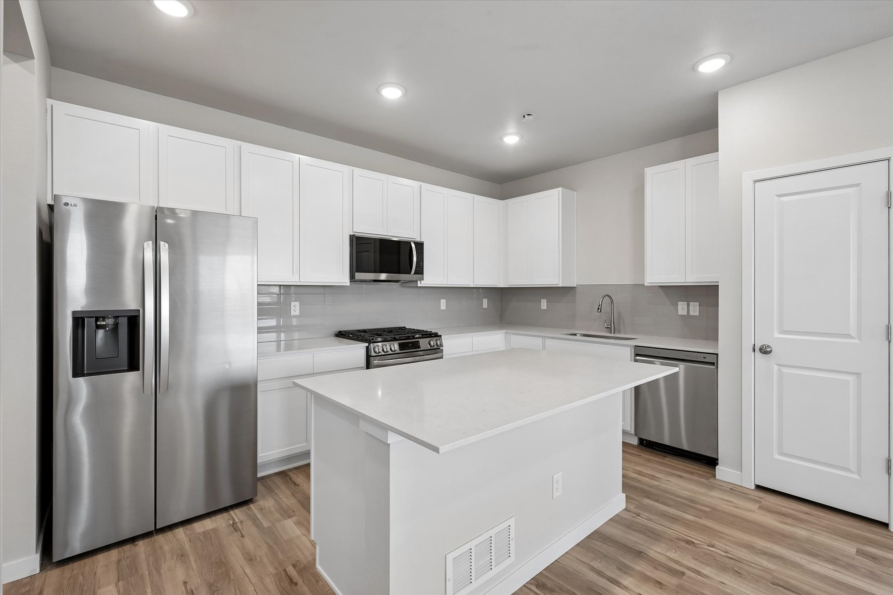 A kitchen with white cabinets.
