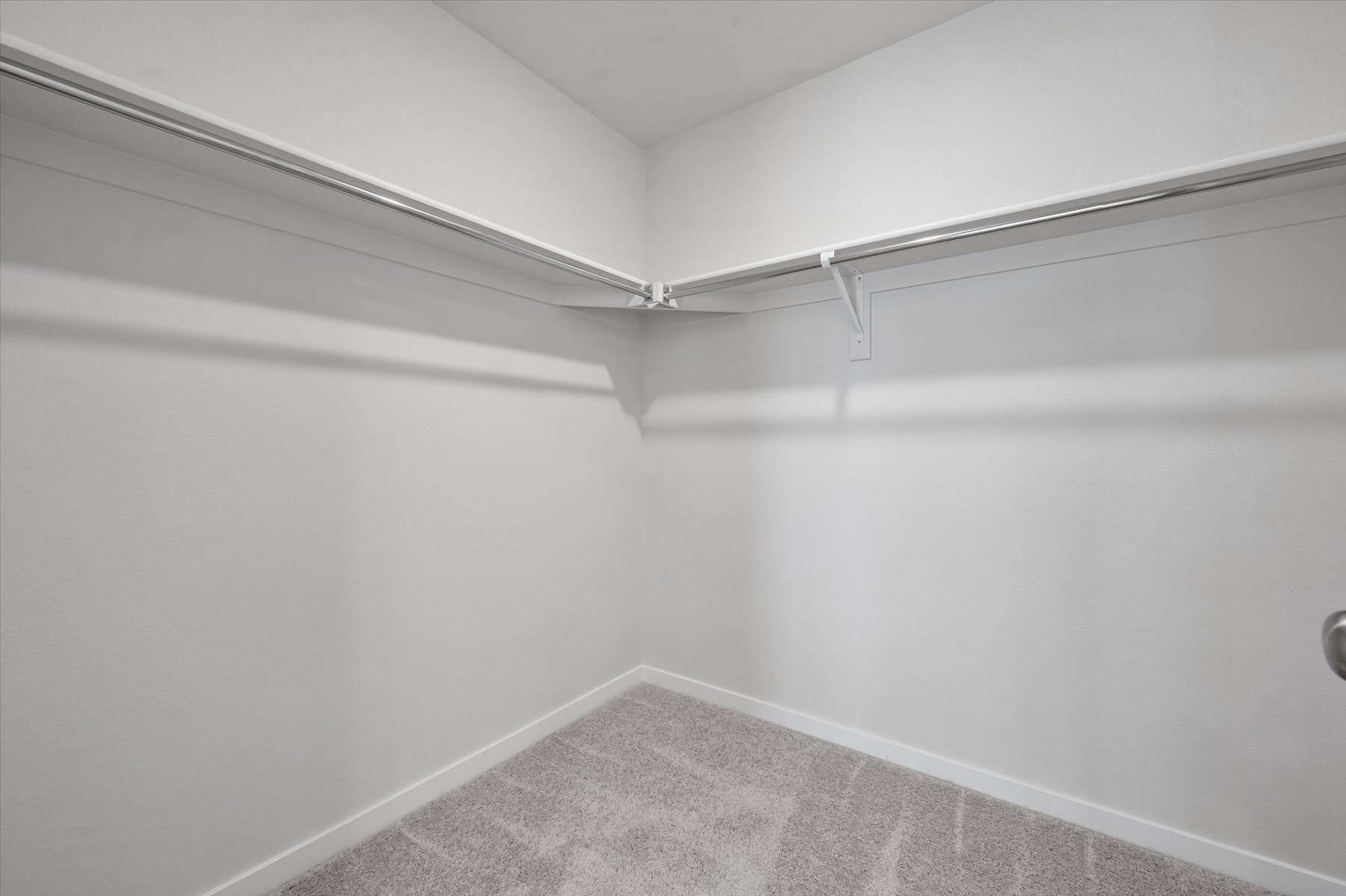 A white hallway with a grey floor.