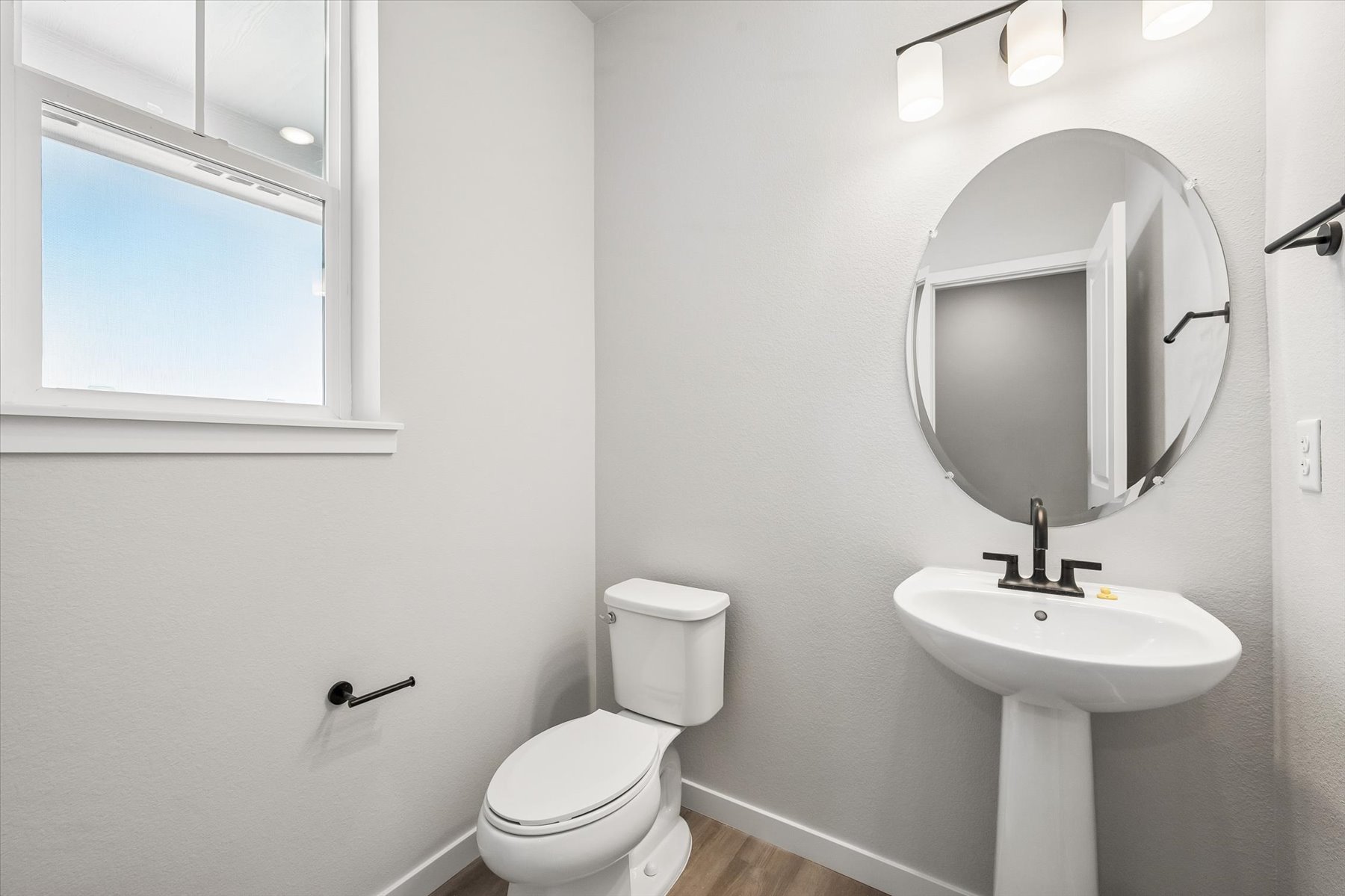 A bathroom with a round mirror.