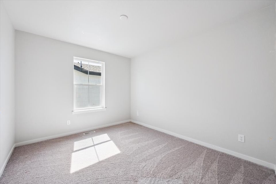 A room with a window and carpet.