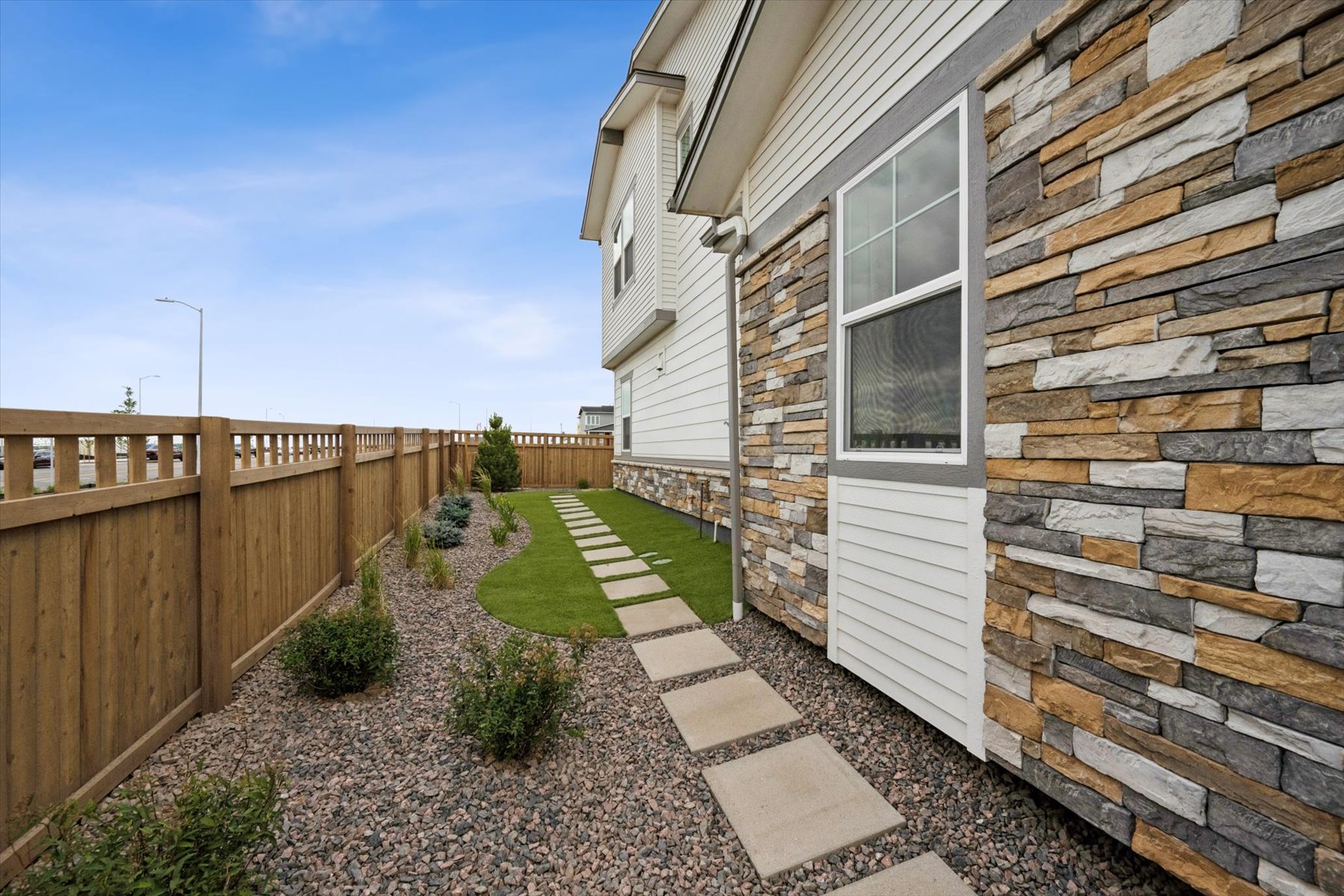 A stone wall next to a house.