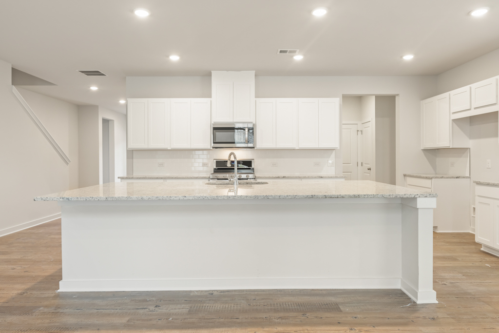 A kitchen with white cabinets.