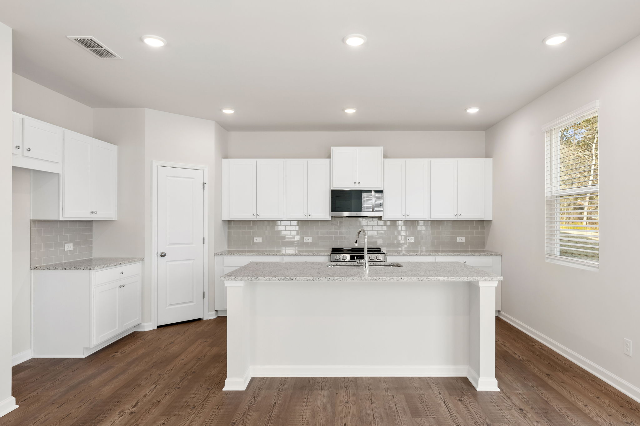 A kitchen with white cabinets.