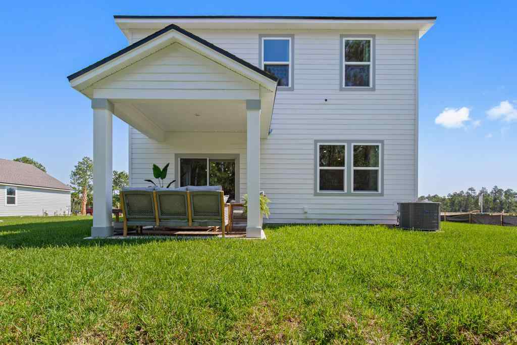 A house with a bench in the front yard.