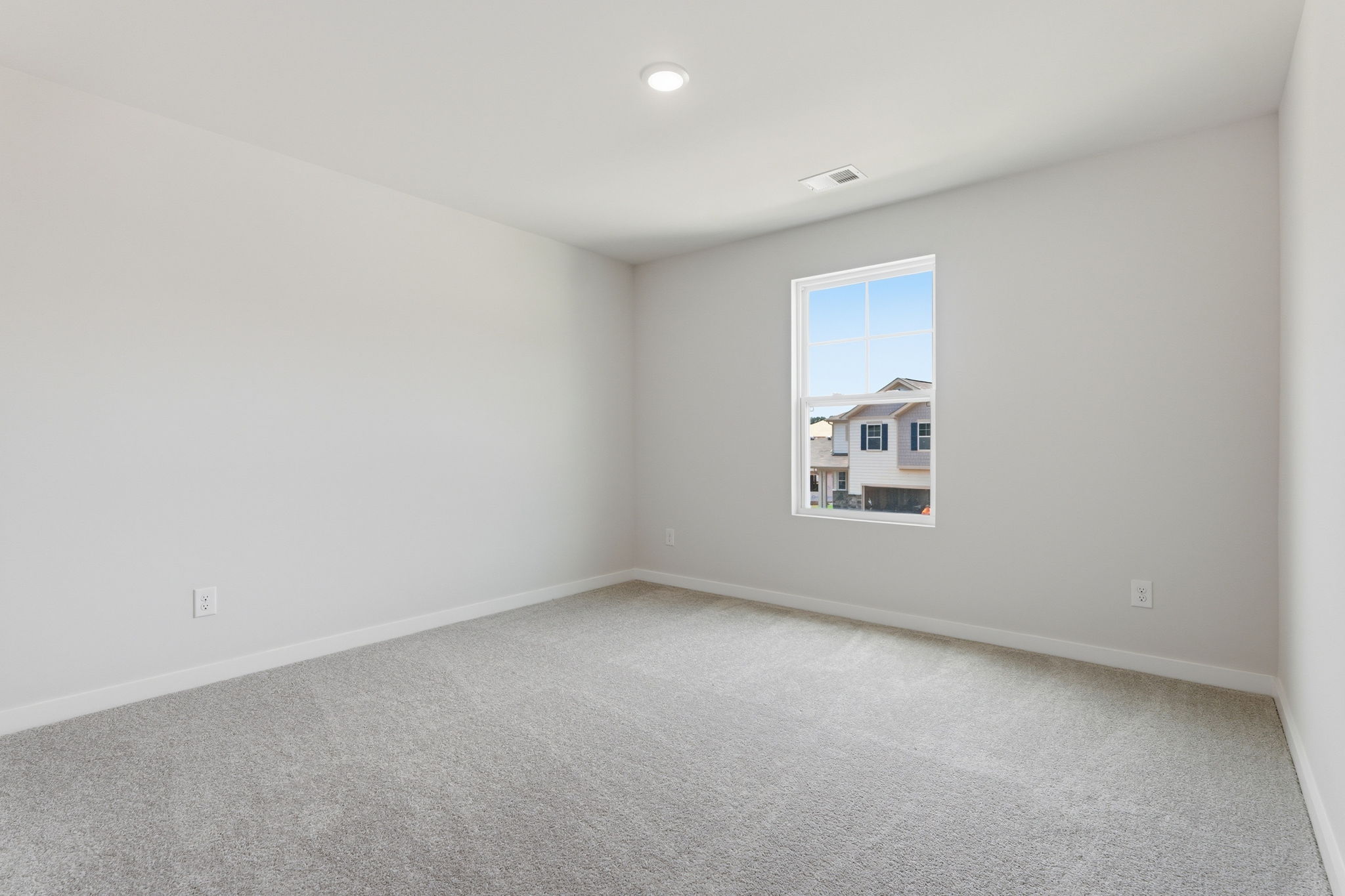 A room with a window and a carpet.