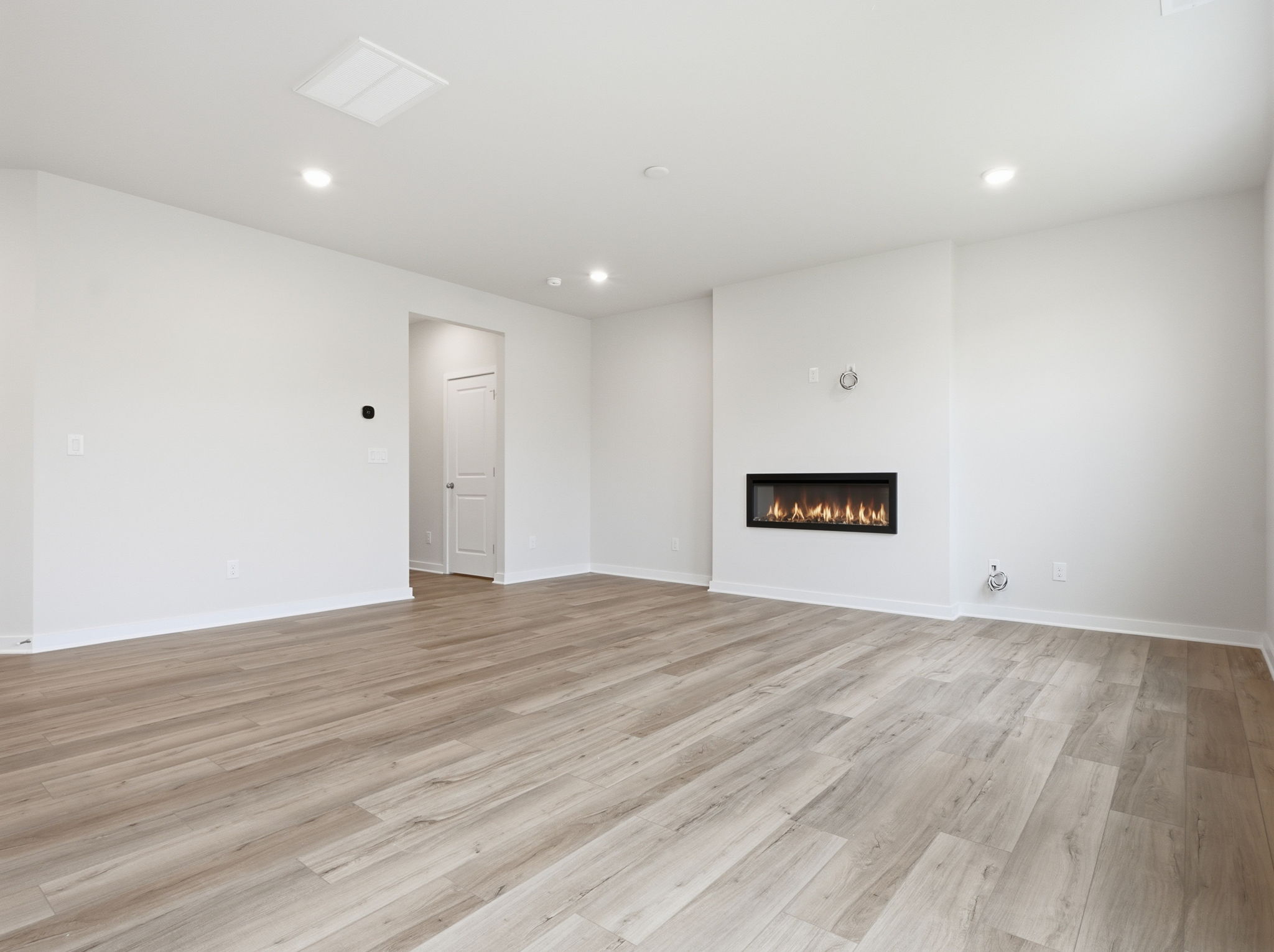 A room with a wood floor and a fireplace.