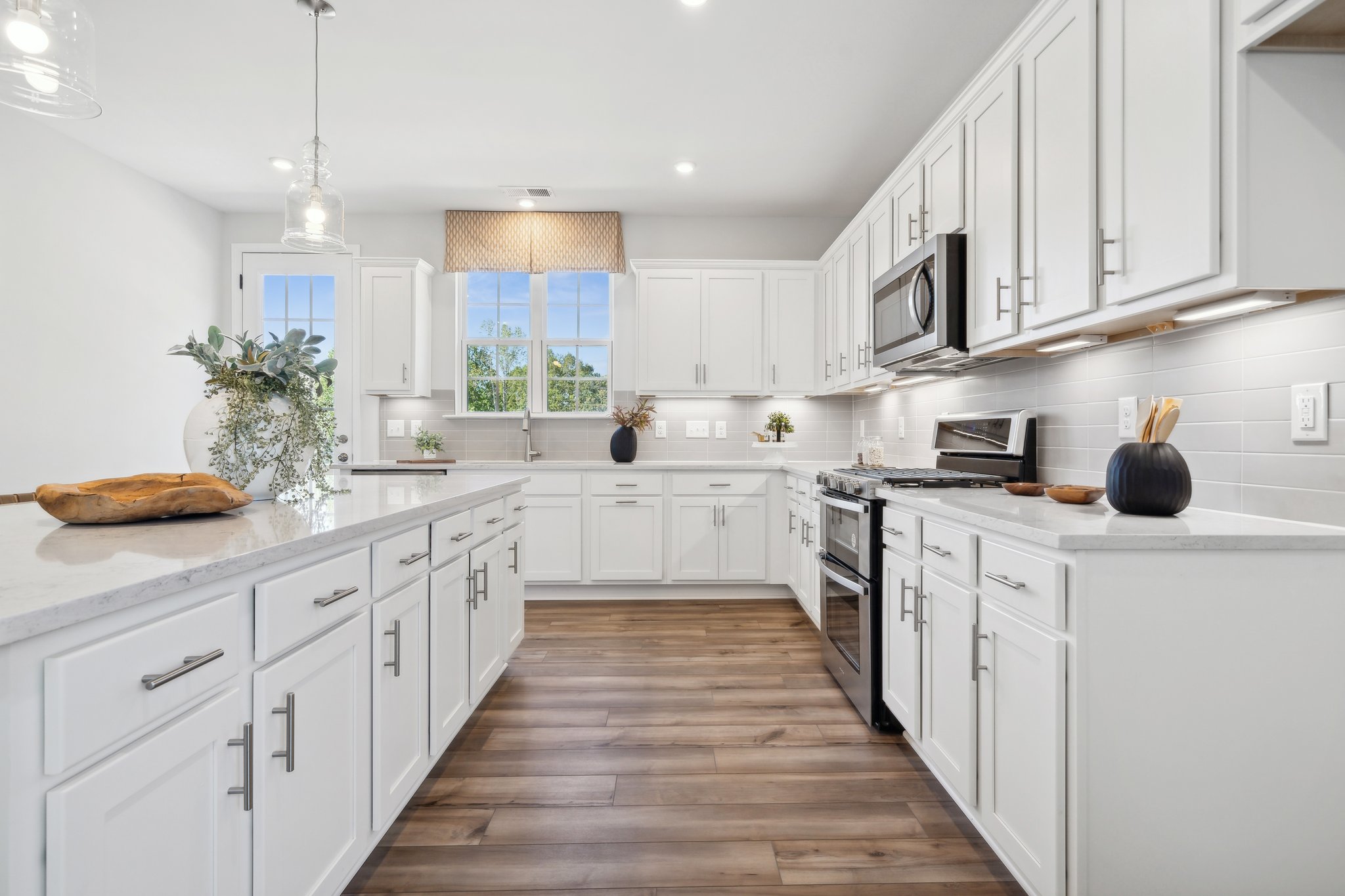 A kitchen with white cabinets.