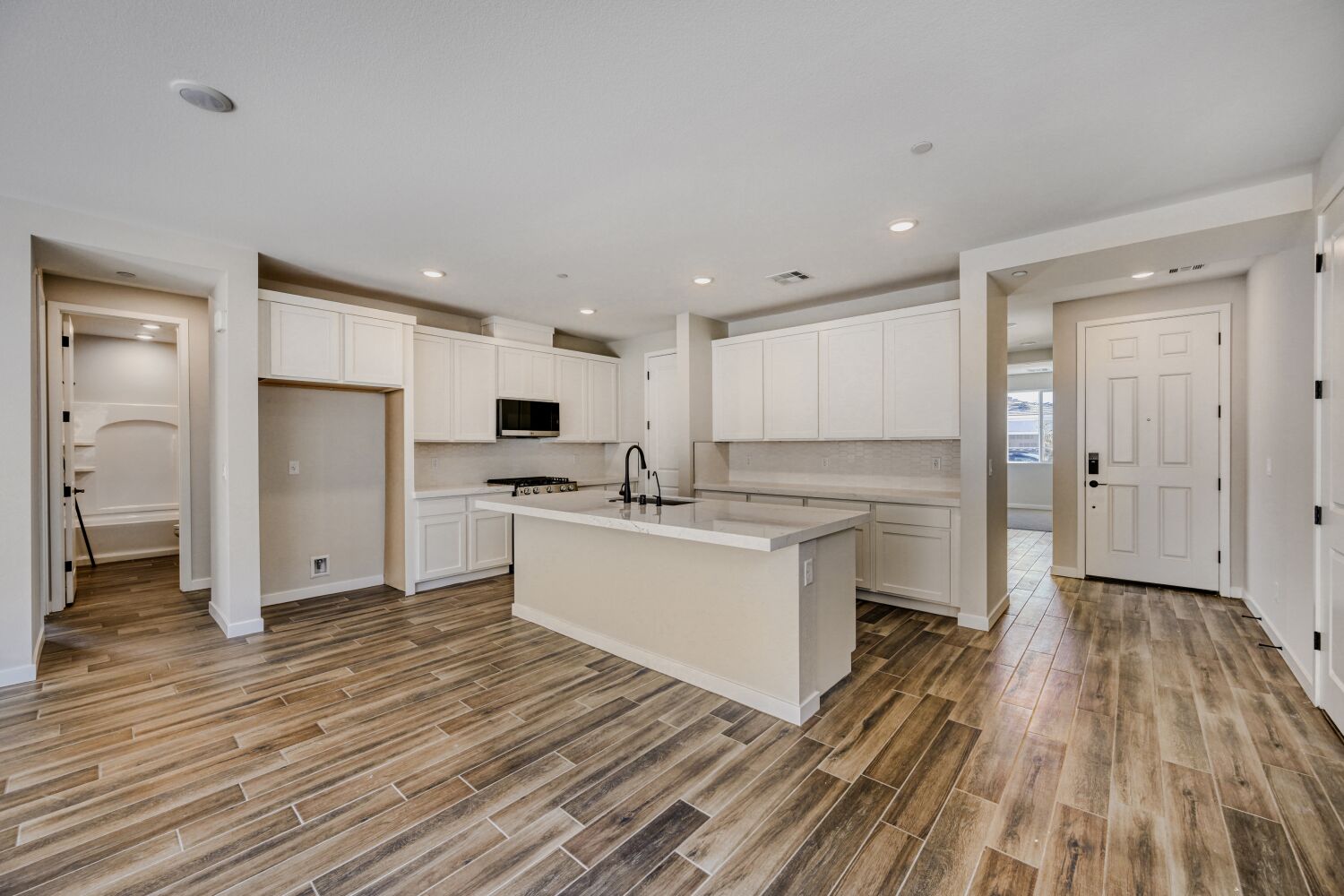 A kitchen with white cabinets.
